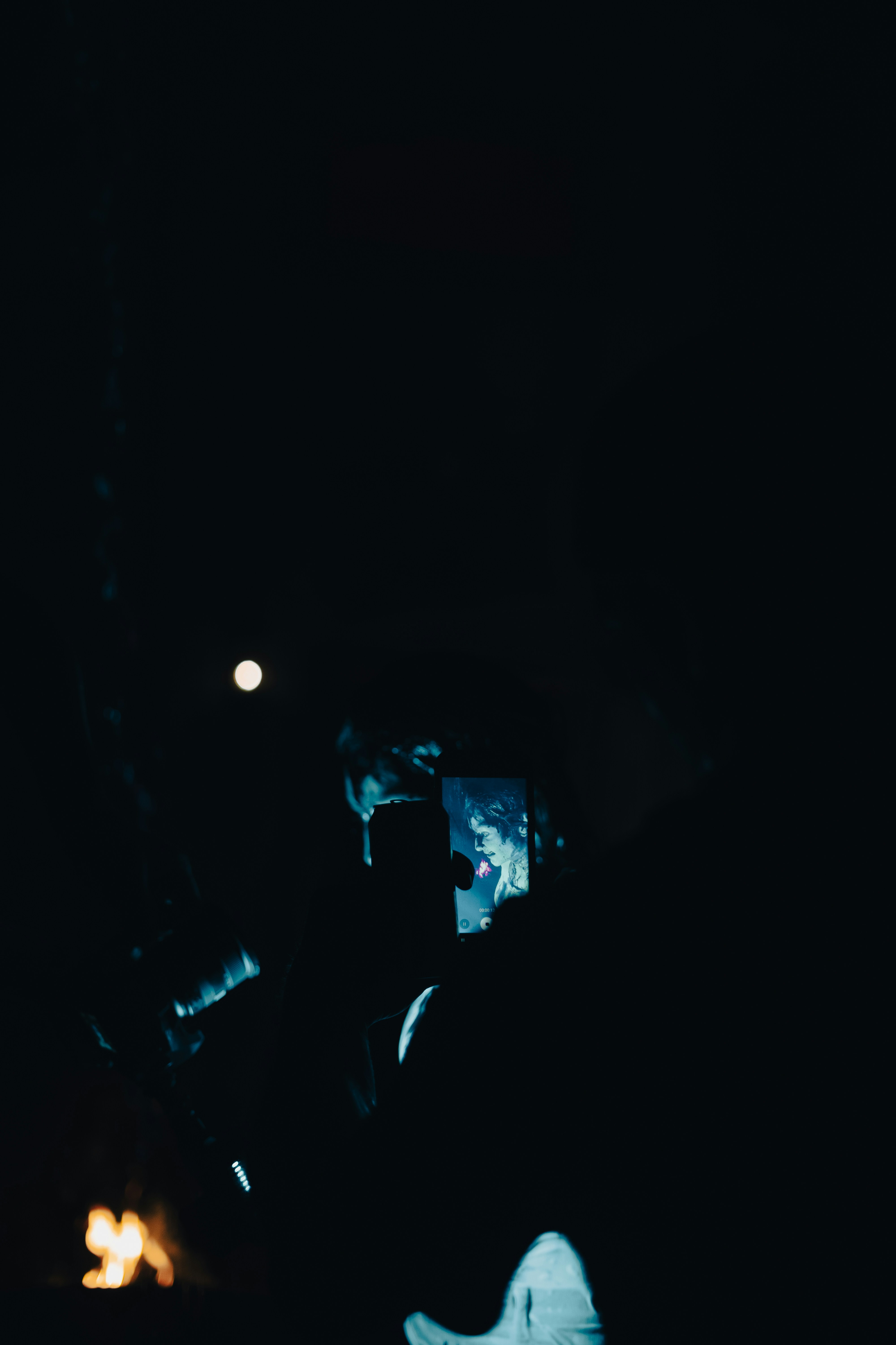 Silhouette einer Person, die nachts ein Handy hält
