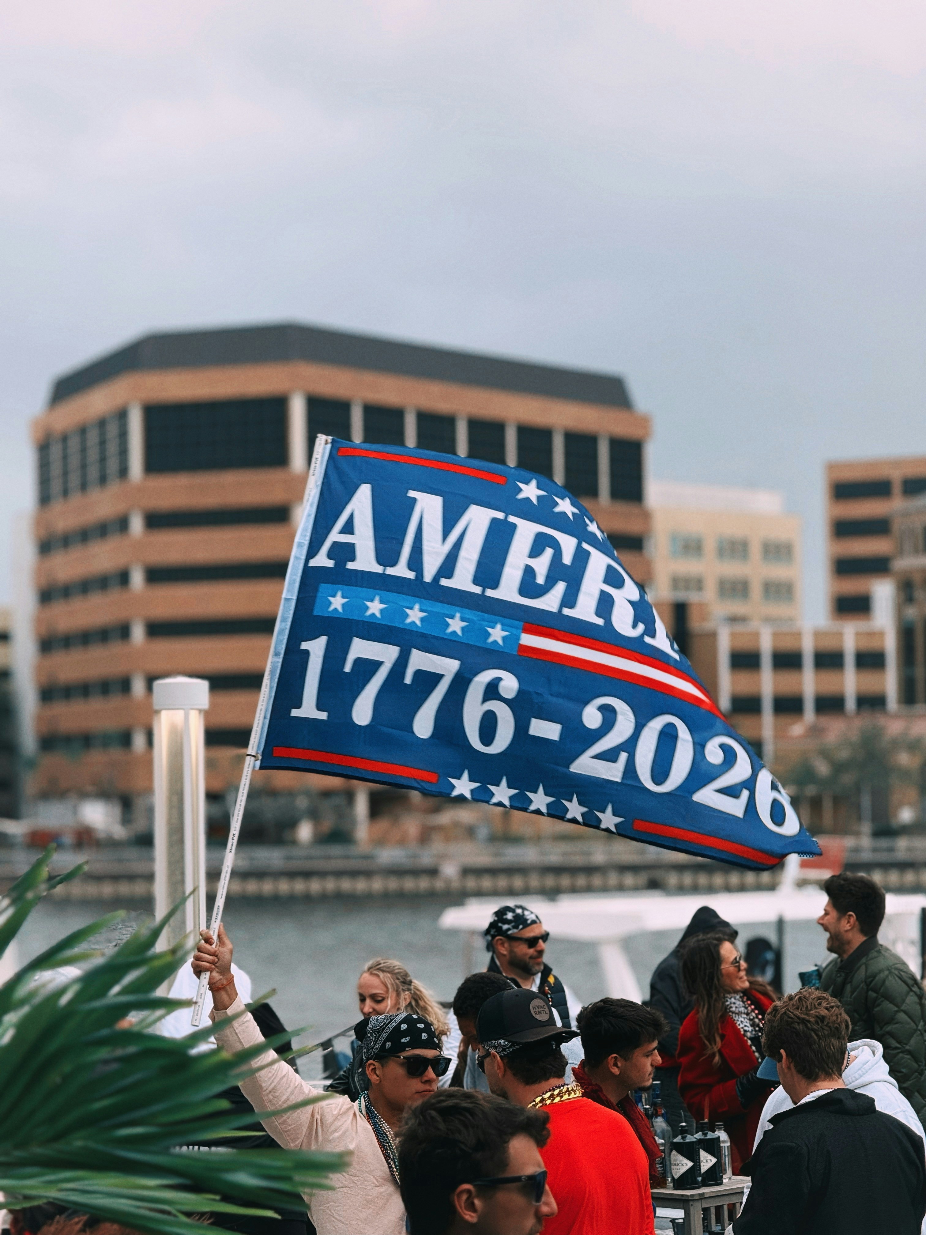 People holding an american flag with 1776-2026