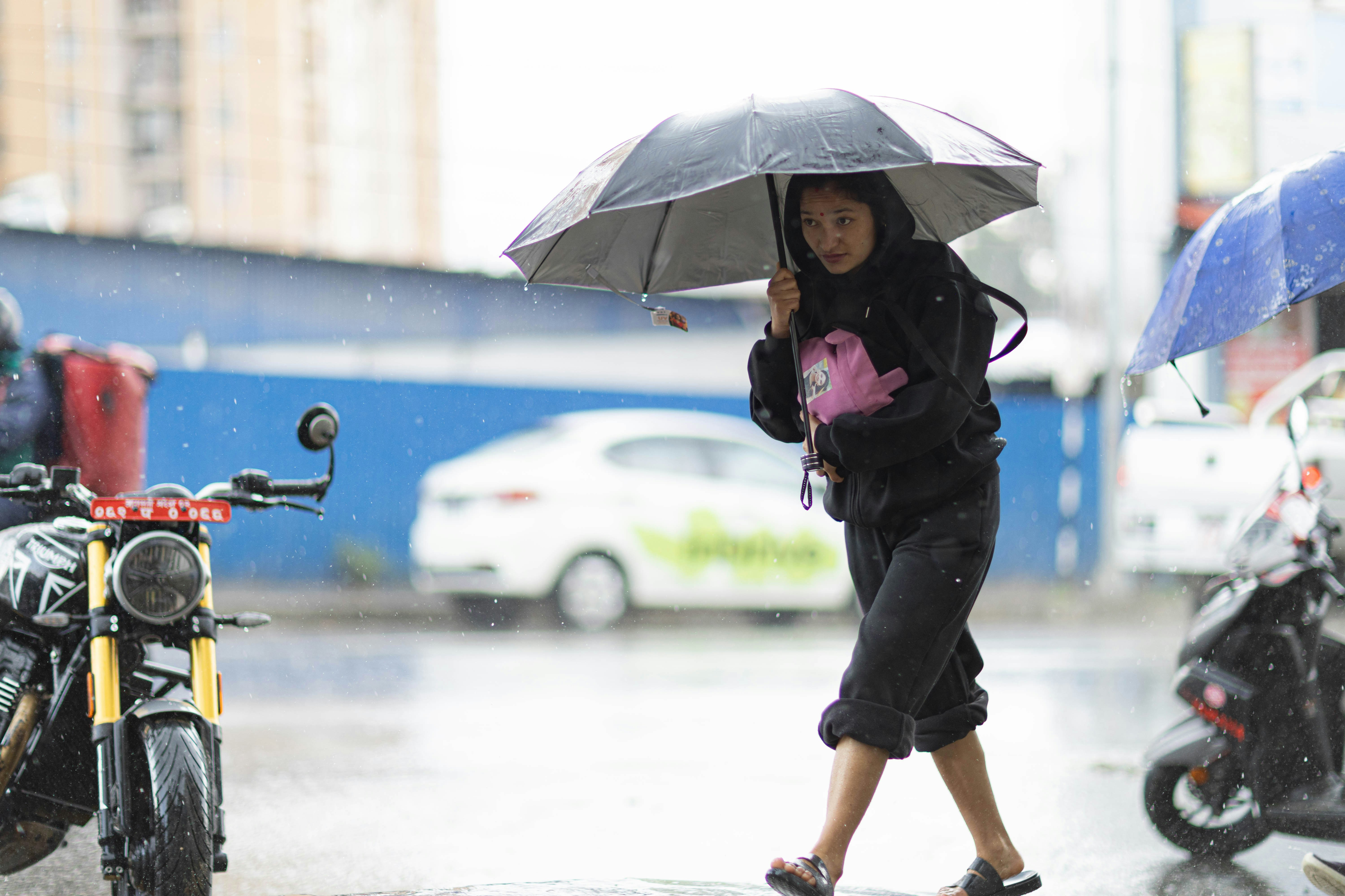 雨の中、傘を持った人が歩く。