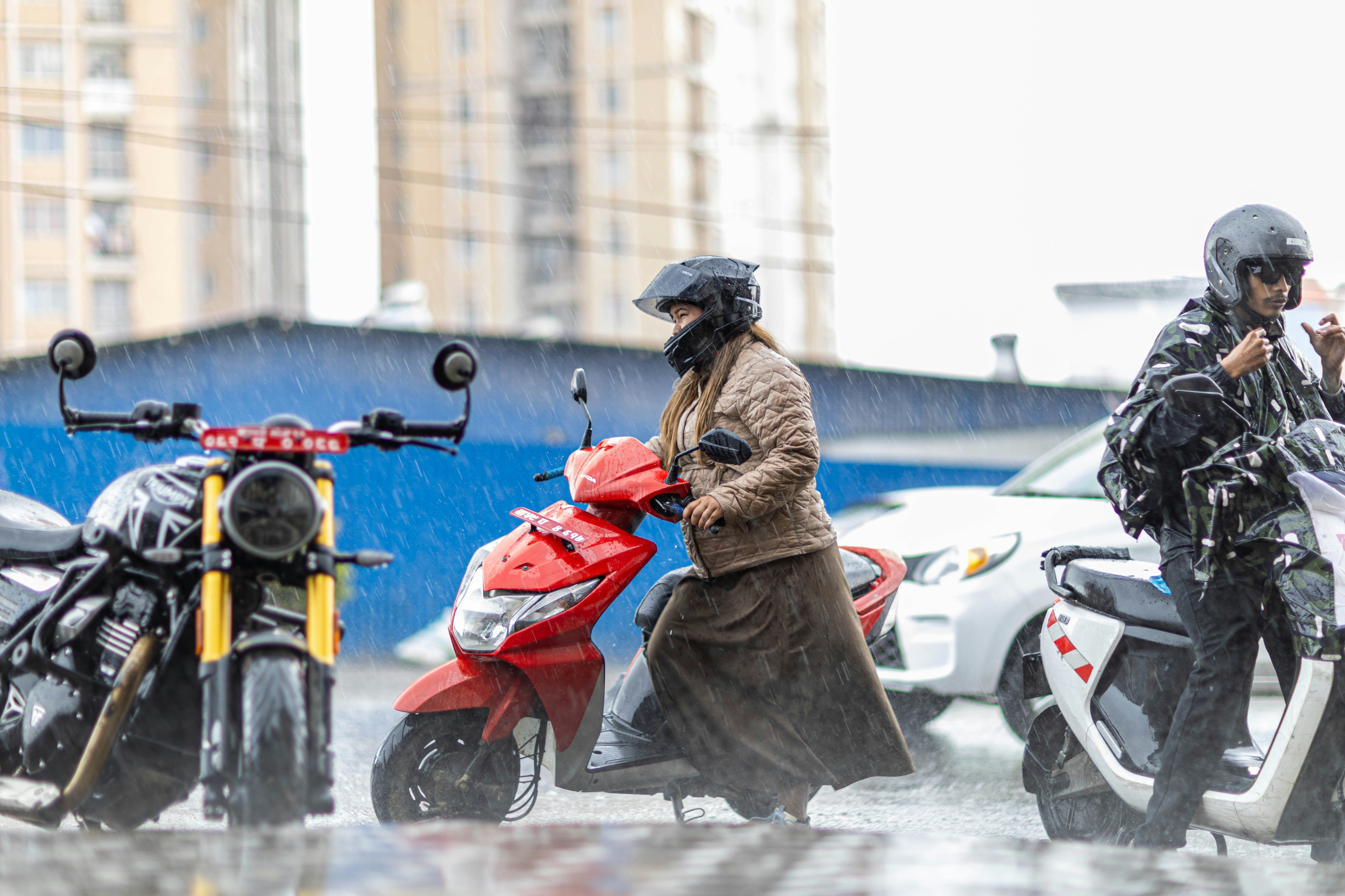 雨の中でスクーターやバイクに乗っている人々