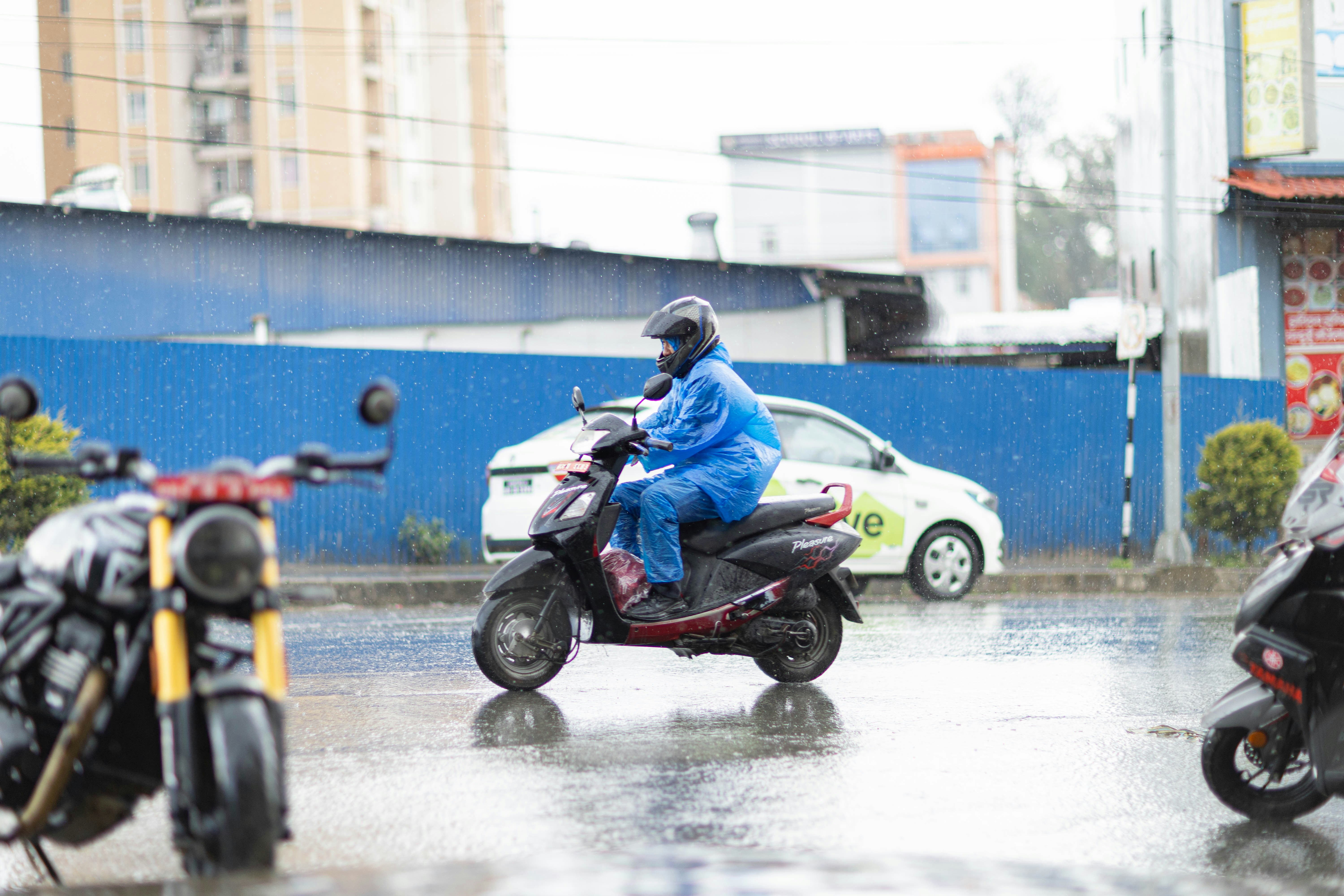 雨の中でスクーターに乗る男