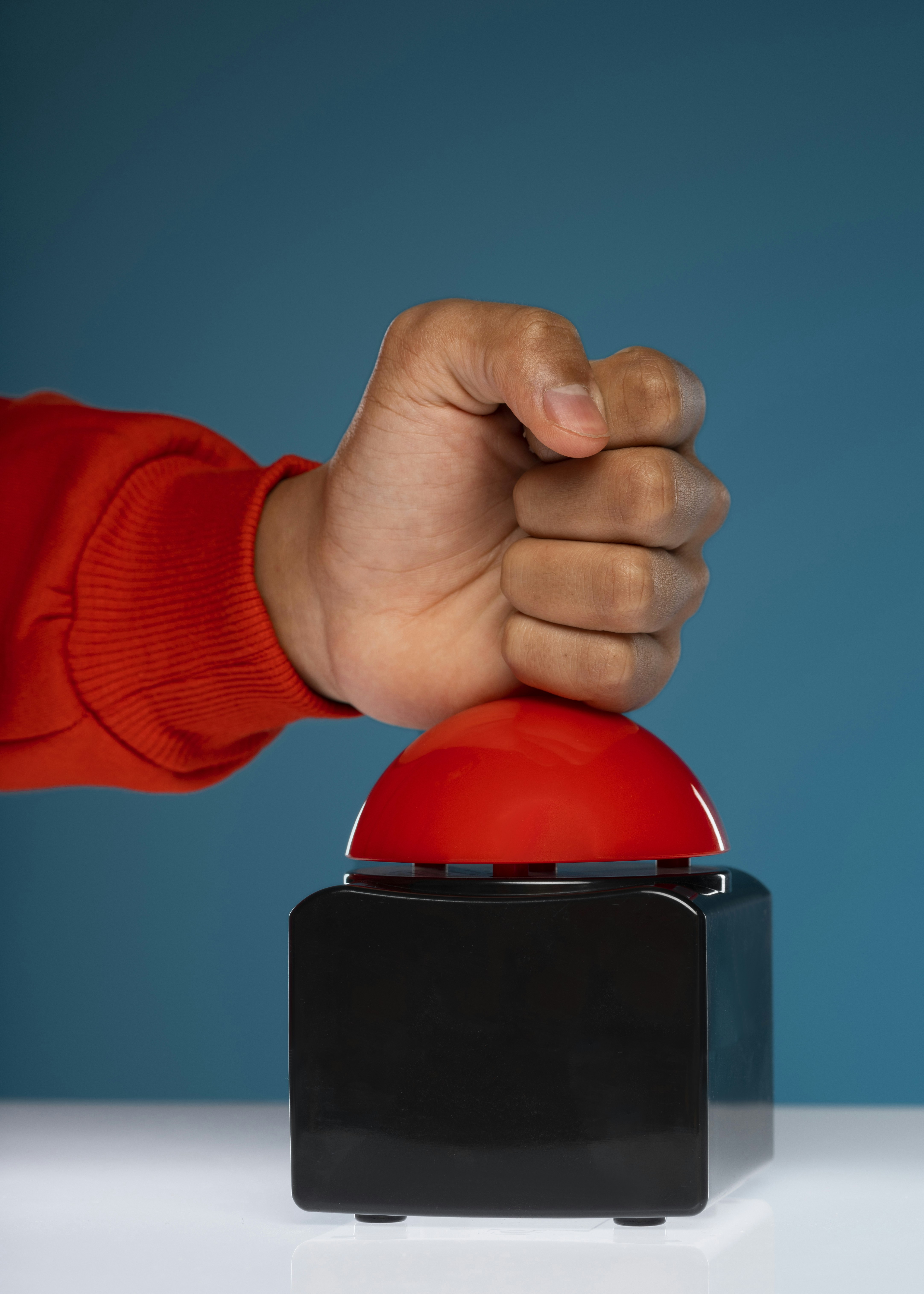 Hand pressing a large red button
