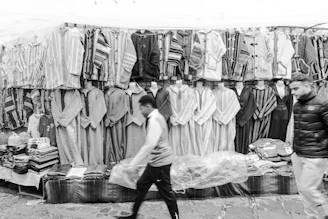 Traditional moroccan djellabas displayed at a market stall.