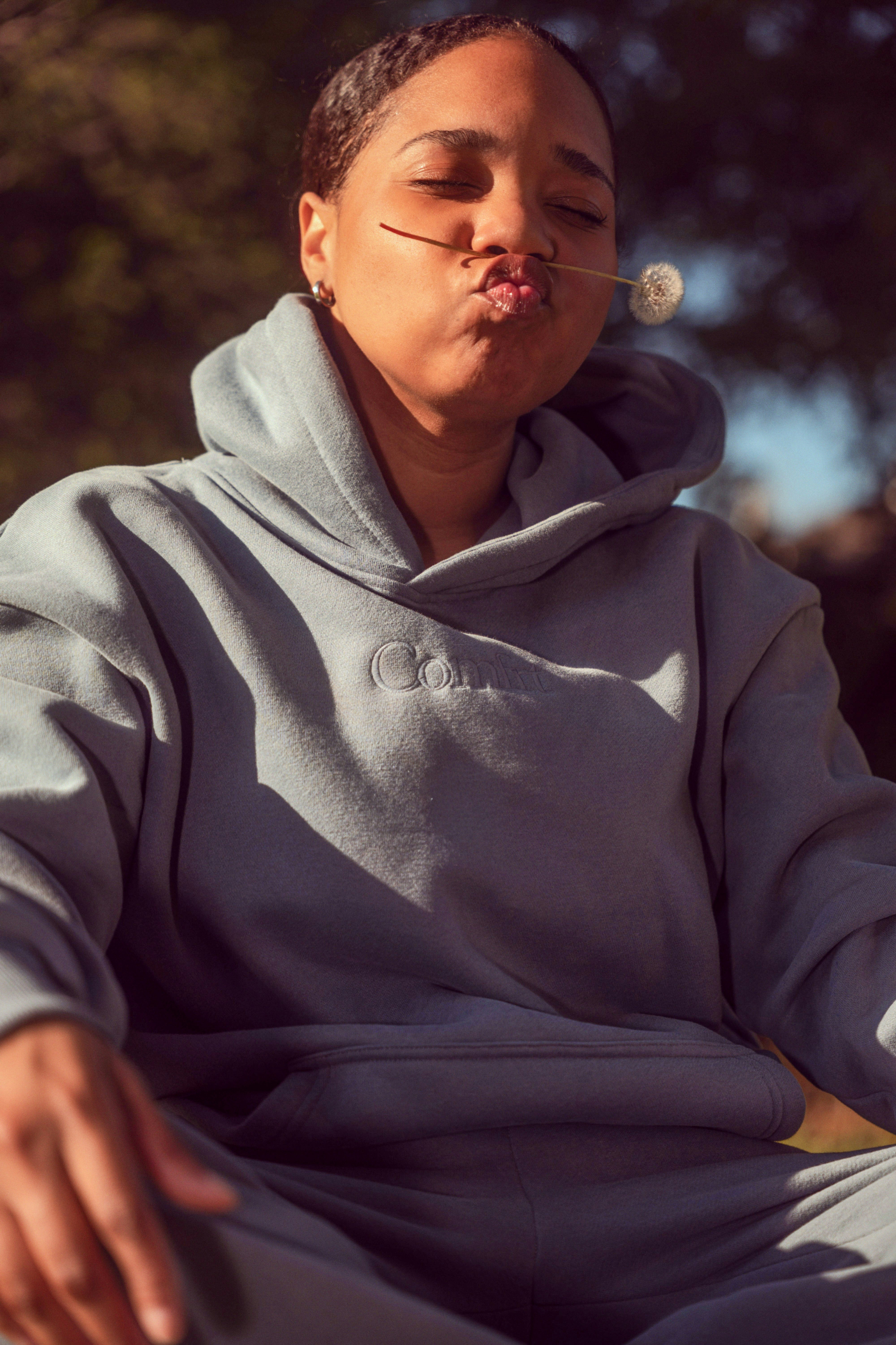 Woman with dandelion stem in mouth