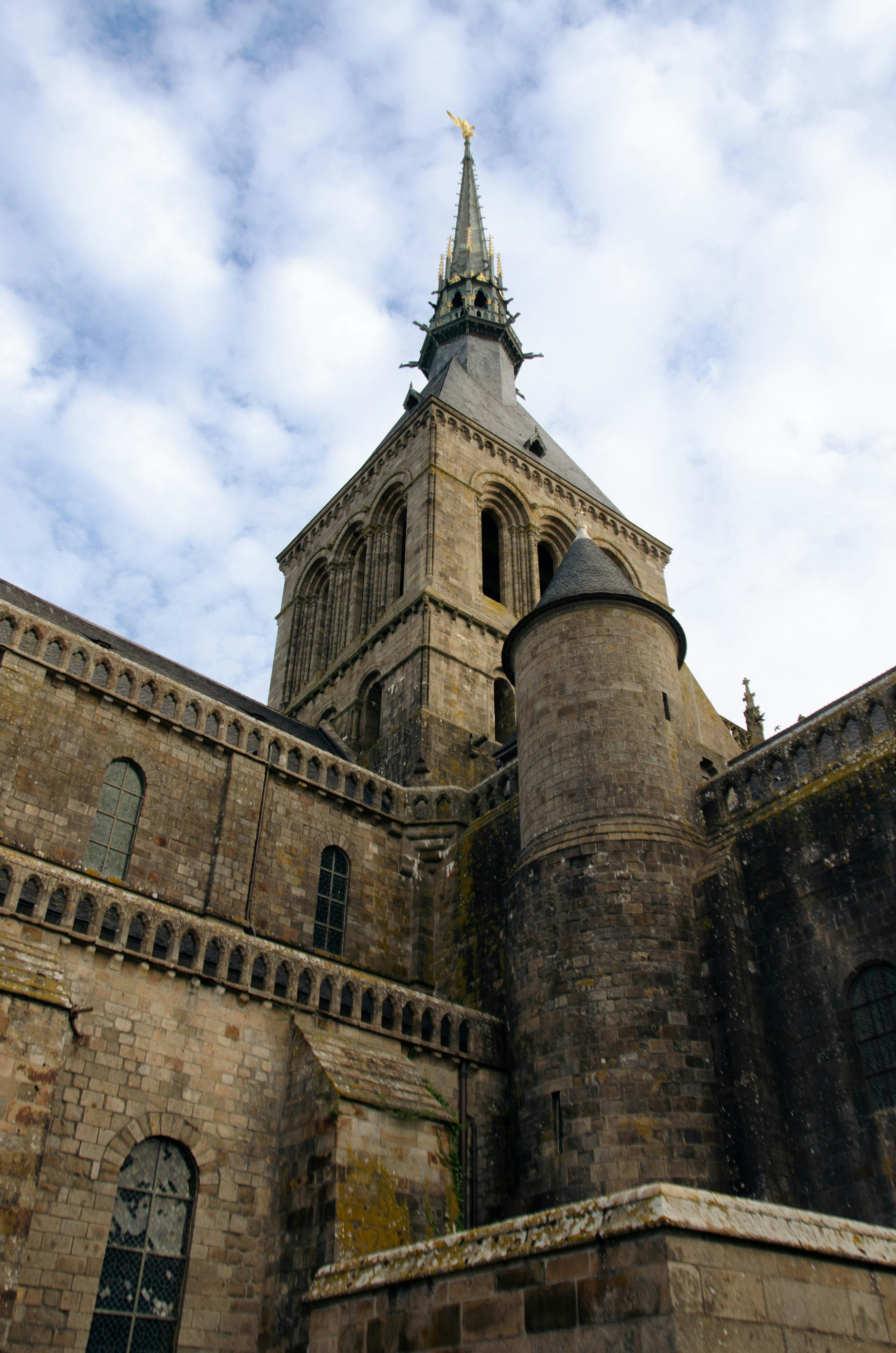 Stone abbey tower against a cloudy sky
