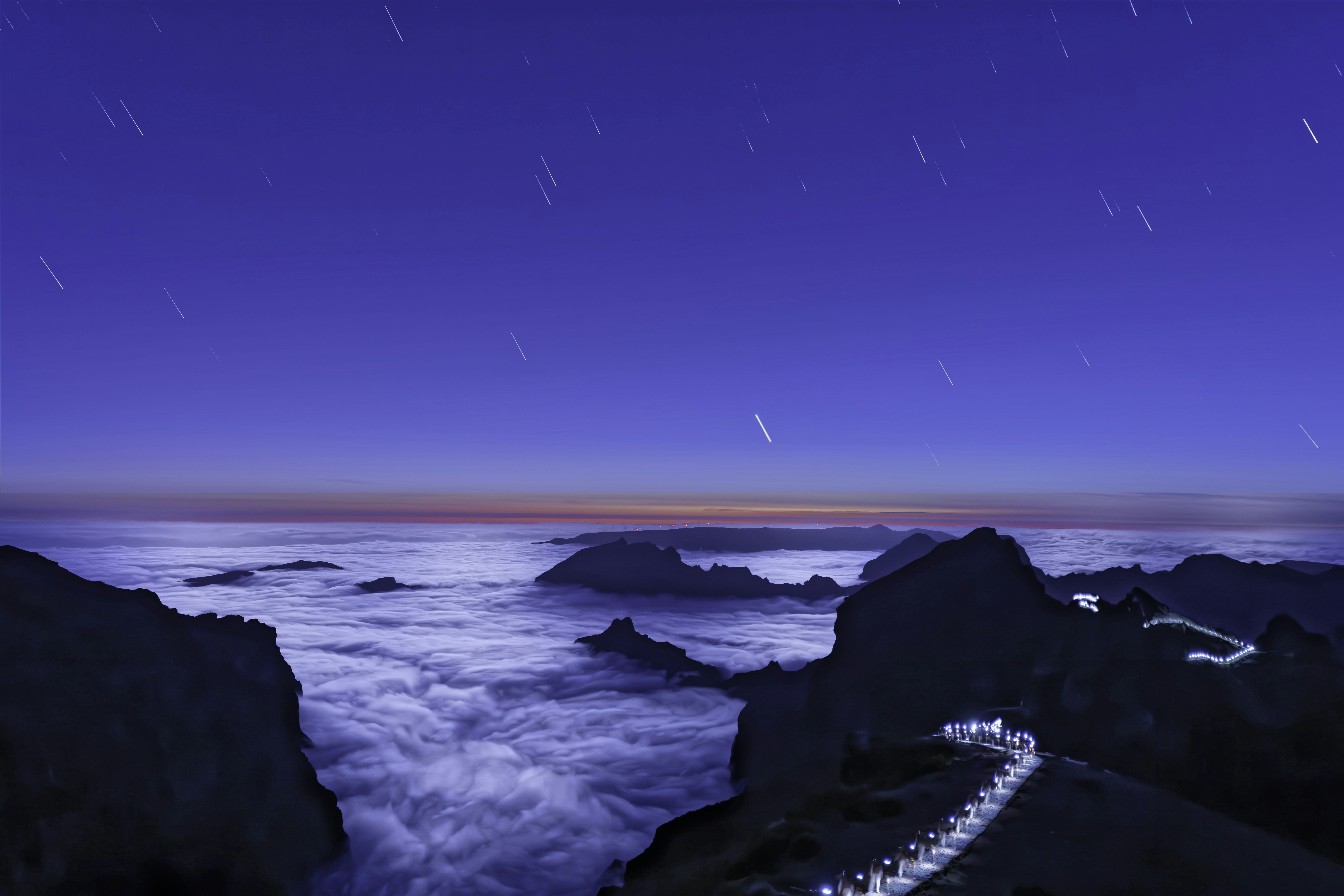 Star trails over a sea of clouds at night
