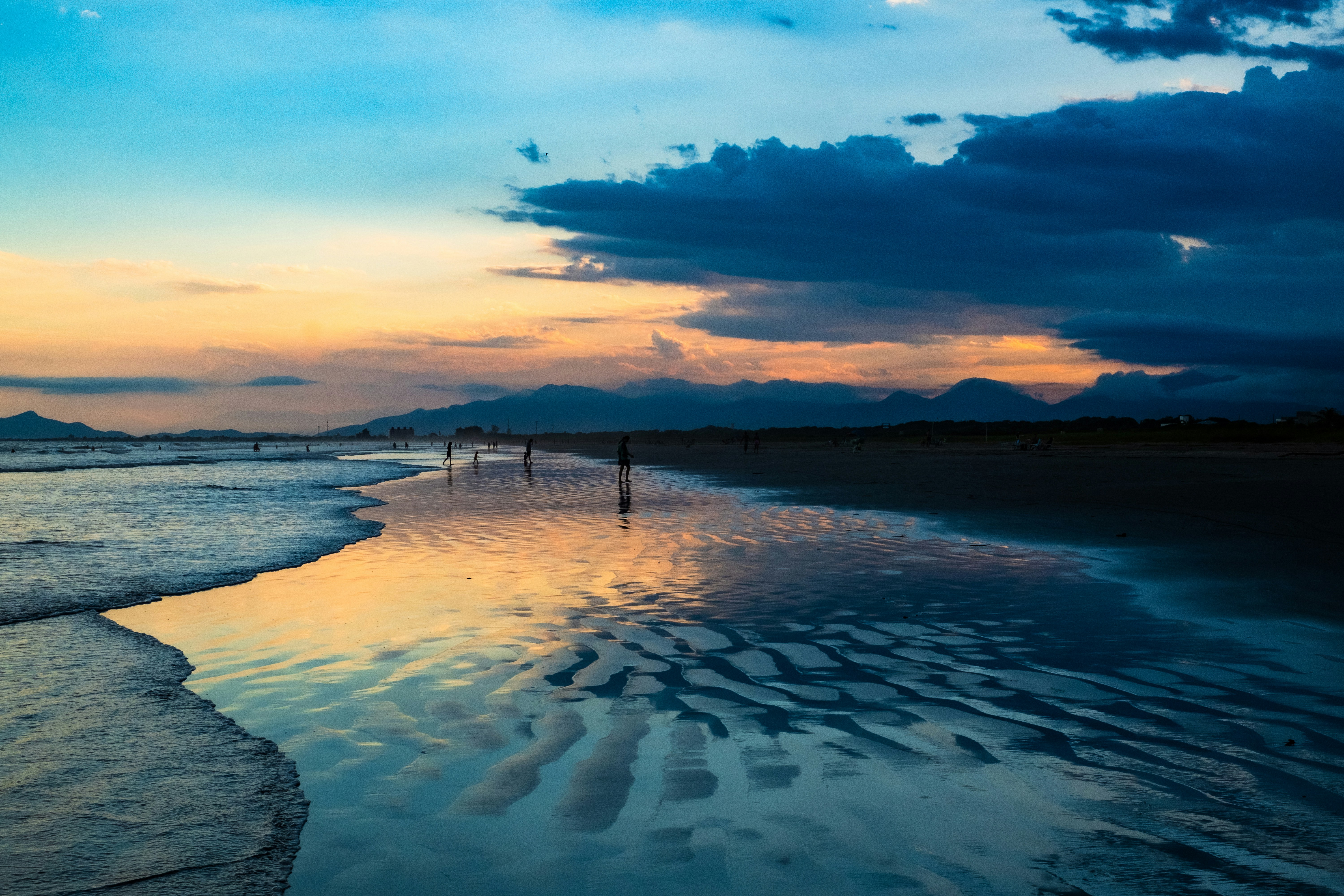 Waves reflecting sunset colors on a sandy beach - Free Photo on Unsplash