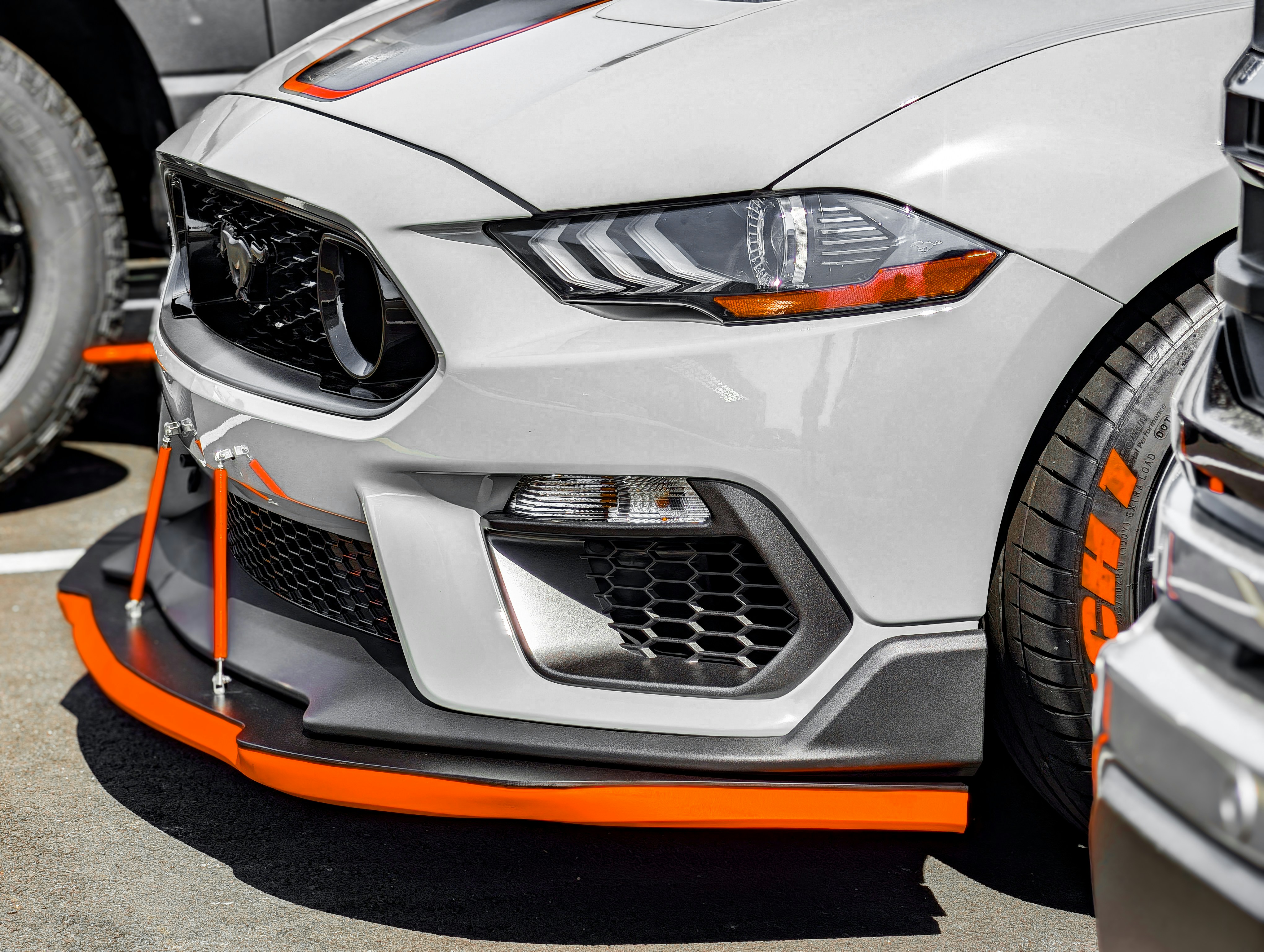 White sports car with orange trim and racing tires