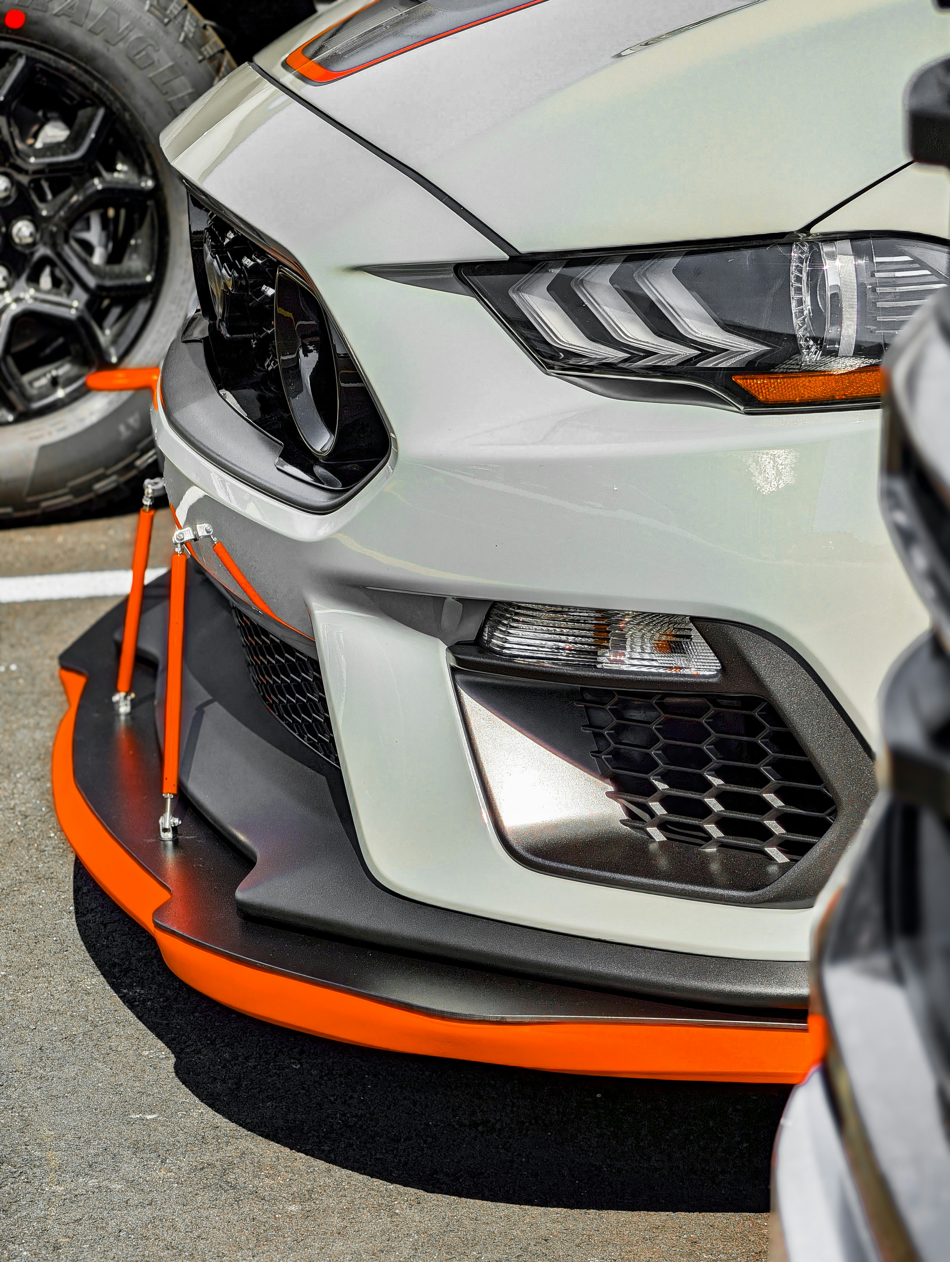 White sports car with orange accents and spoiler