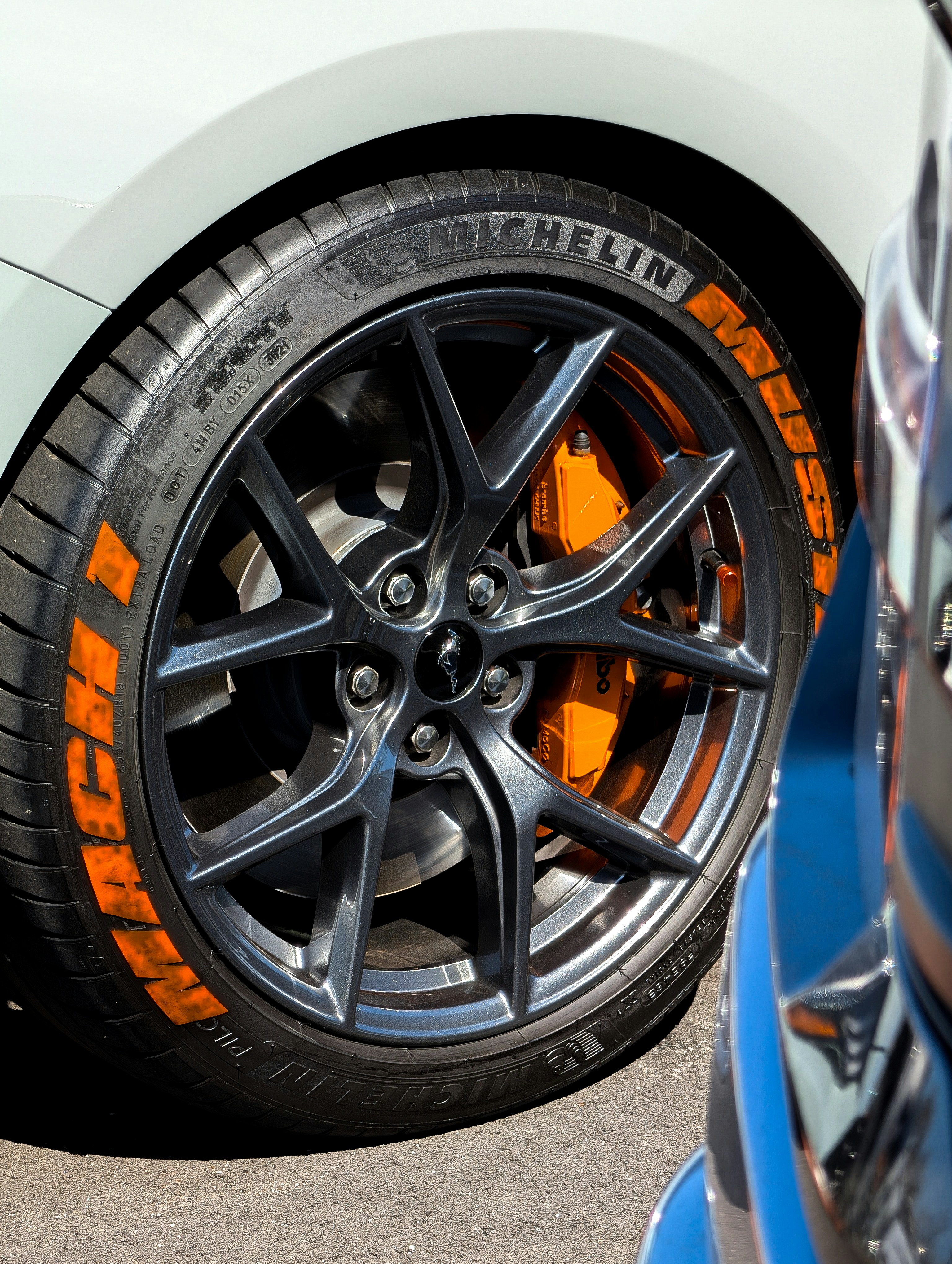 Close-up of a car wheel with orange tire markings.