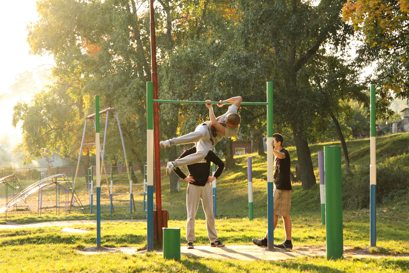 Personas entrenando en aparatos de gimnasio al aire libre en un parque