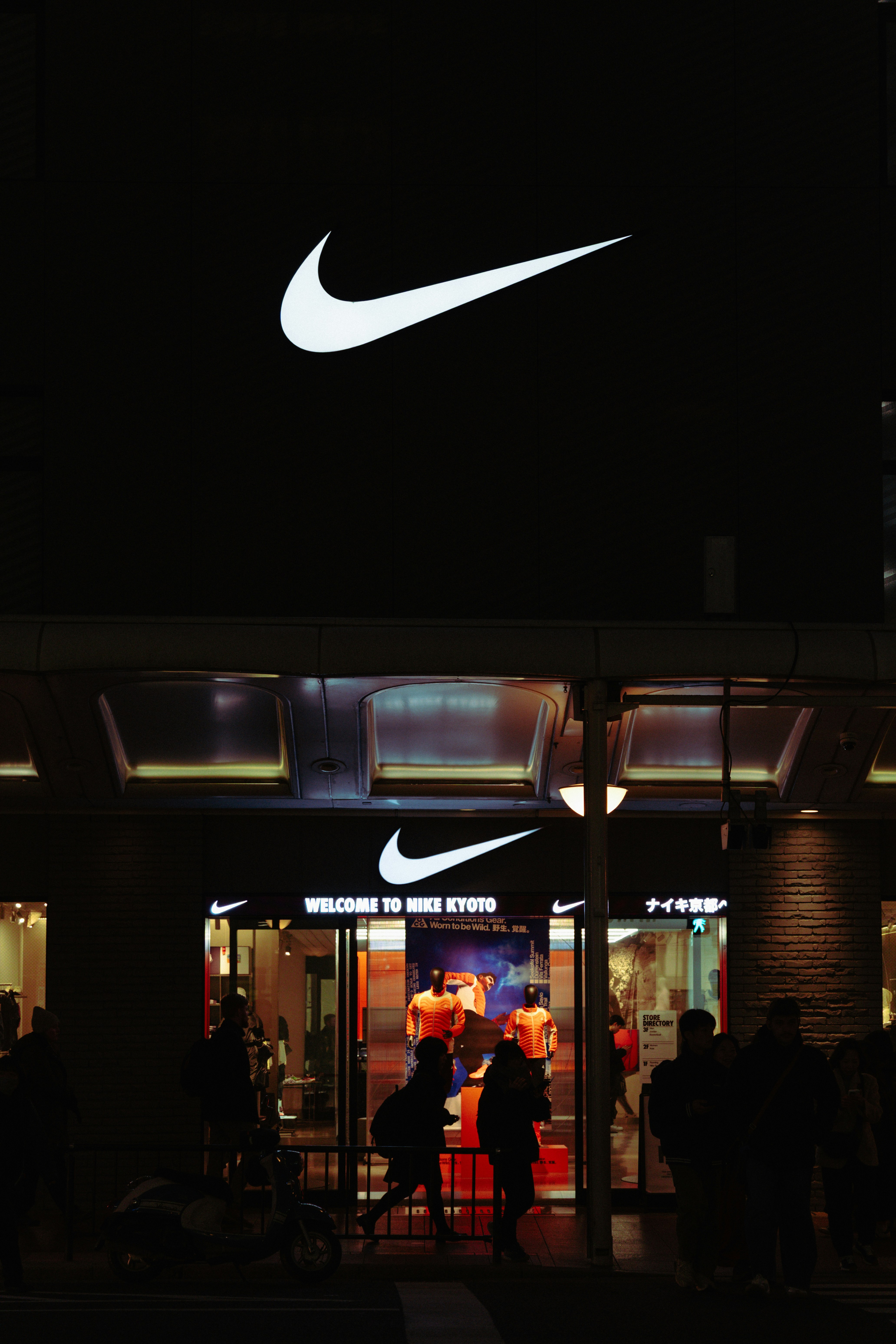 Entrée du magasin Nike la nuit avec un logo illuminé