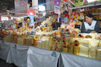 A market stall piled high with many cheeses
