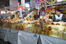 A market stall piled high with many cheeses