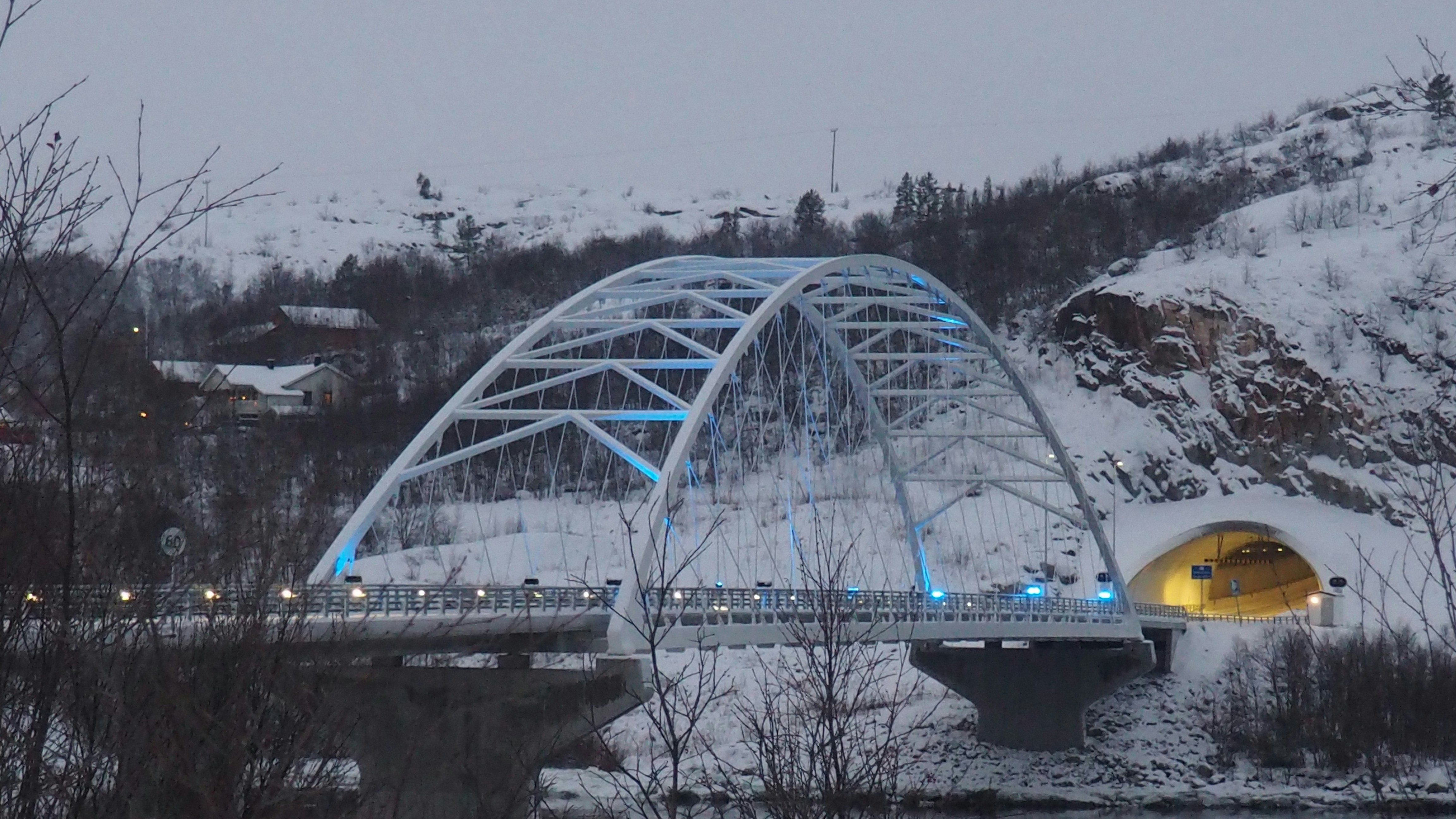 Illuminated arch bridge over a river in winter
