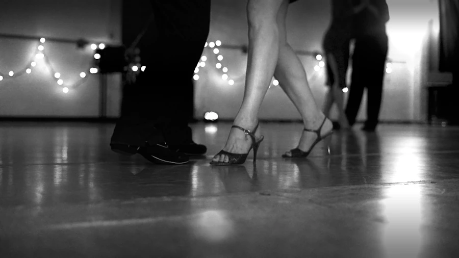Couple performing Argentine tango in a dimly lit venue
