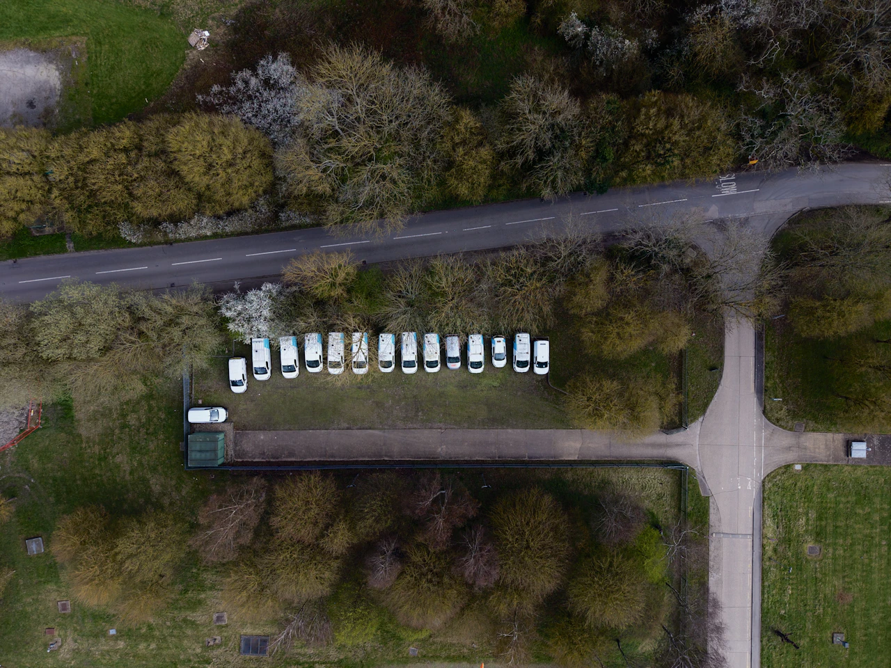 An overhead view of a parked delivery van fleet, the multi-driver capacity route optimization has to sequence each morning