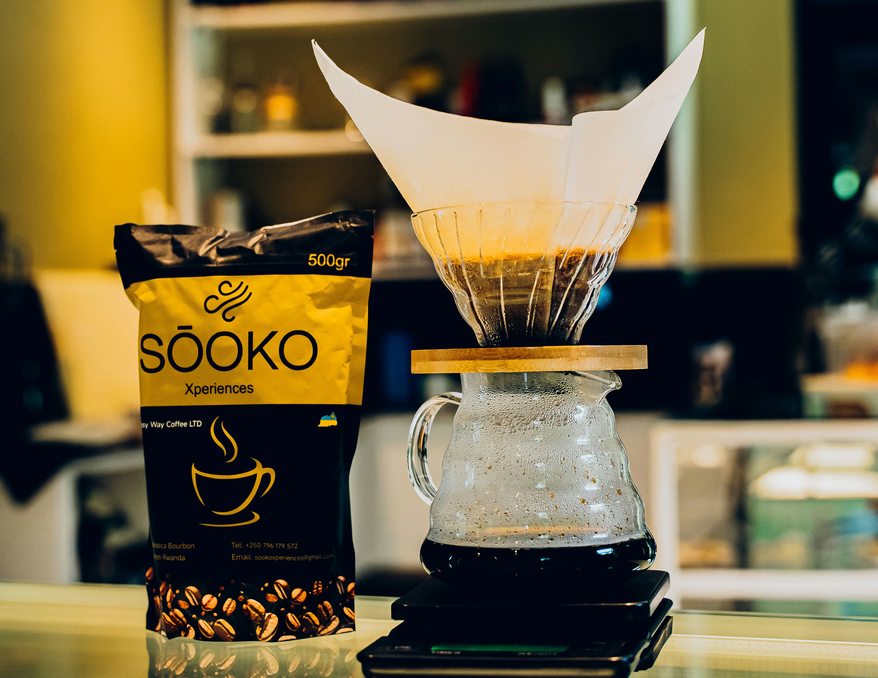 Bag of coffee beans next to pour-over coffee maker