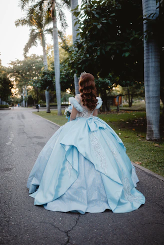 Woman in a blue ballgown walking in a park