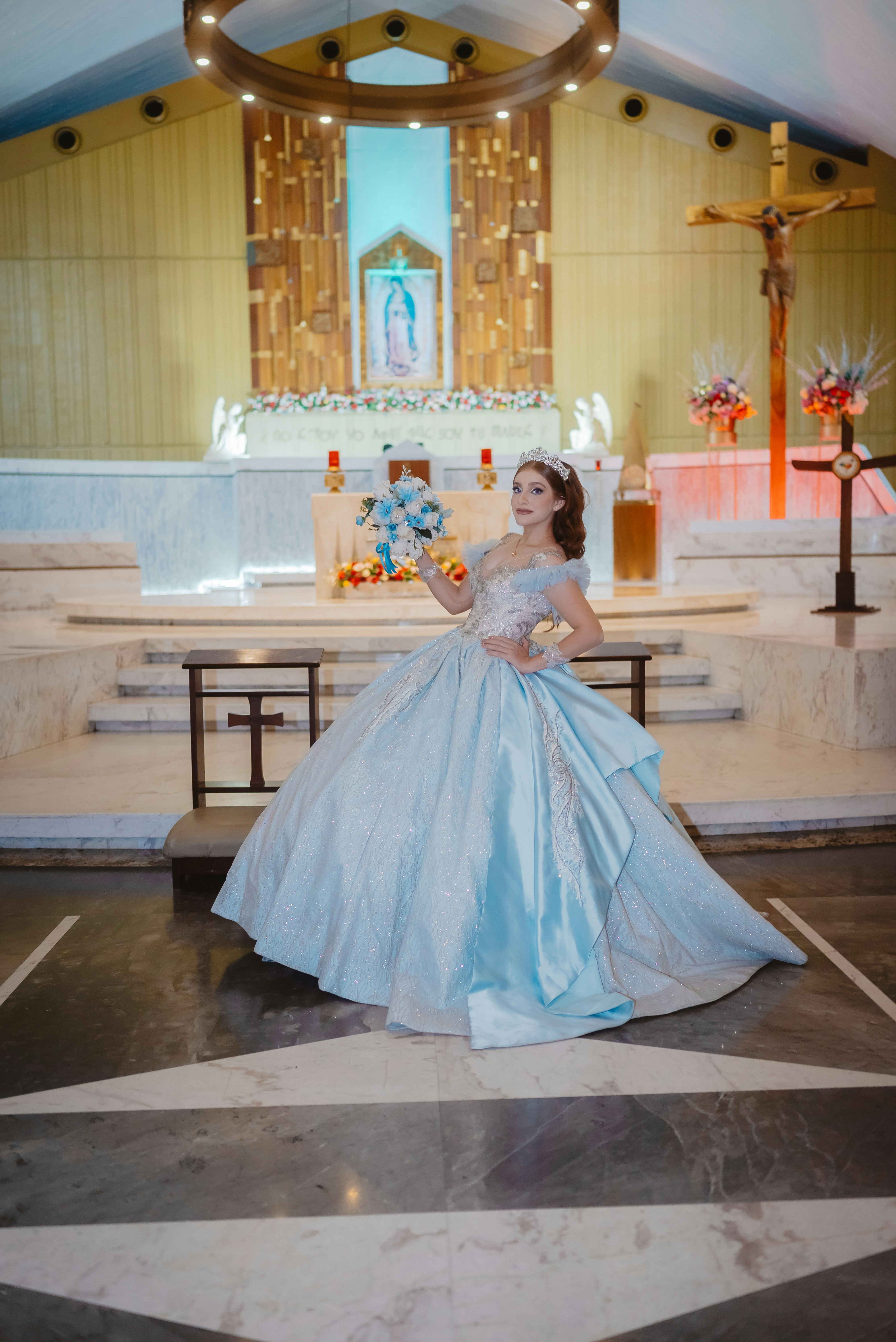 Jeune femme en robe de bal bleue à l’intérieur d’une église
