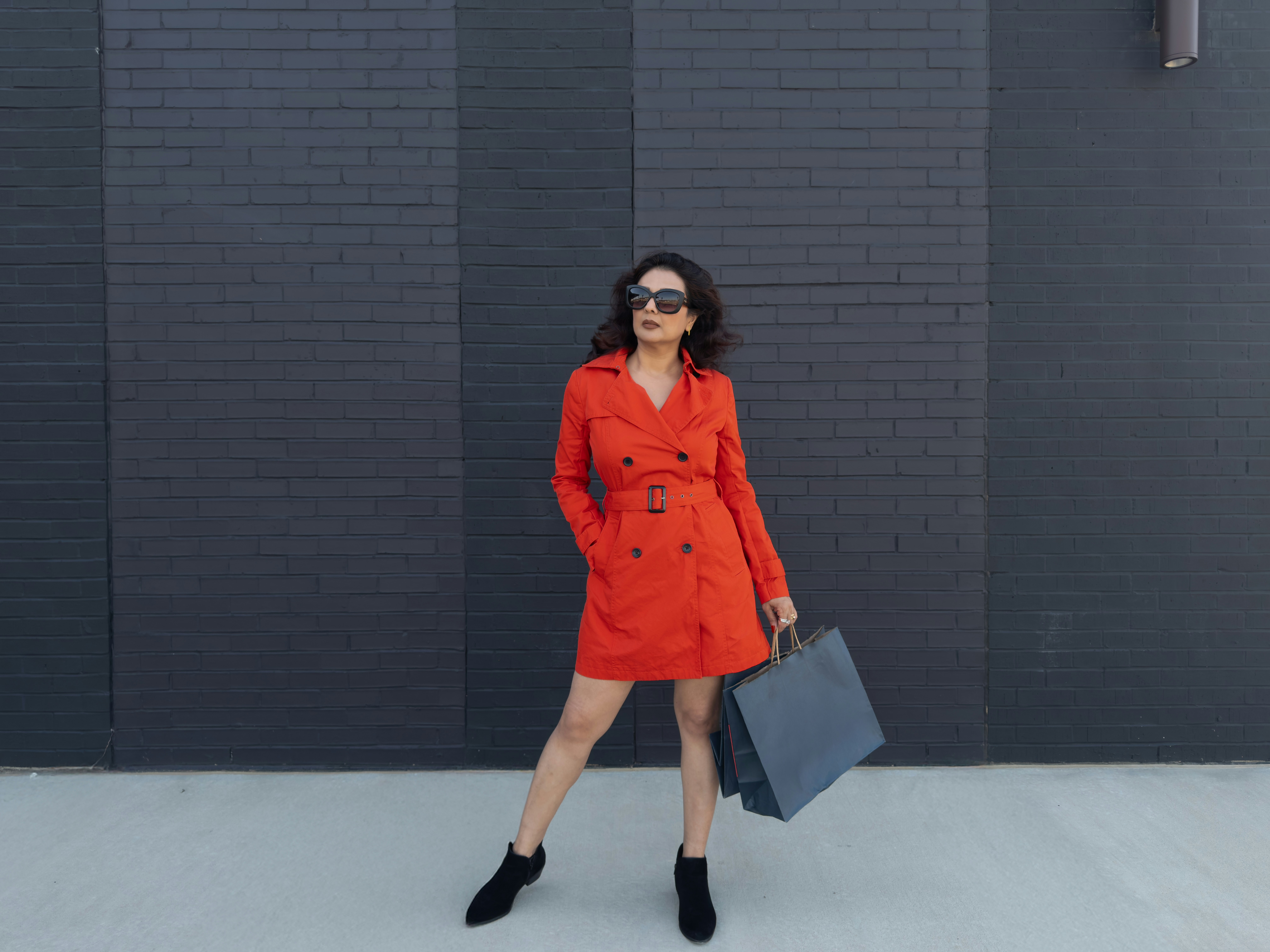 Woman in red dress holding shopping bags