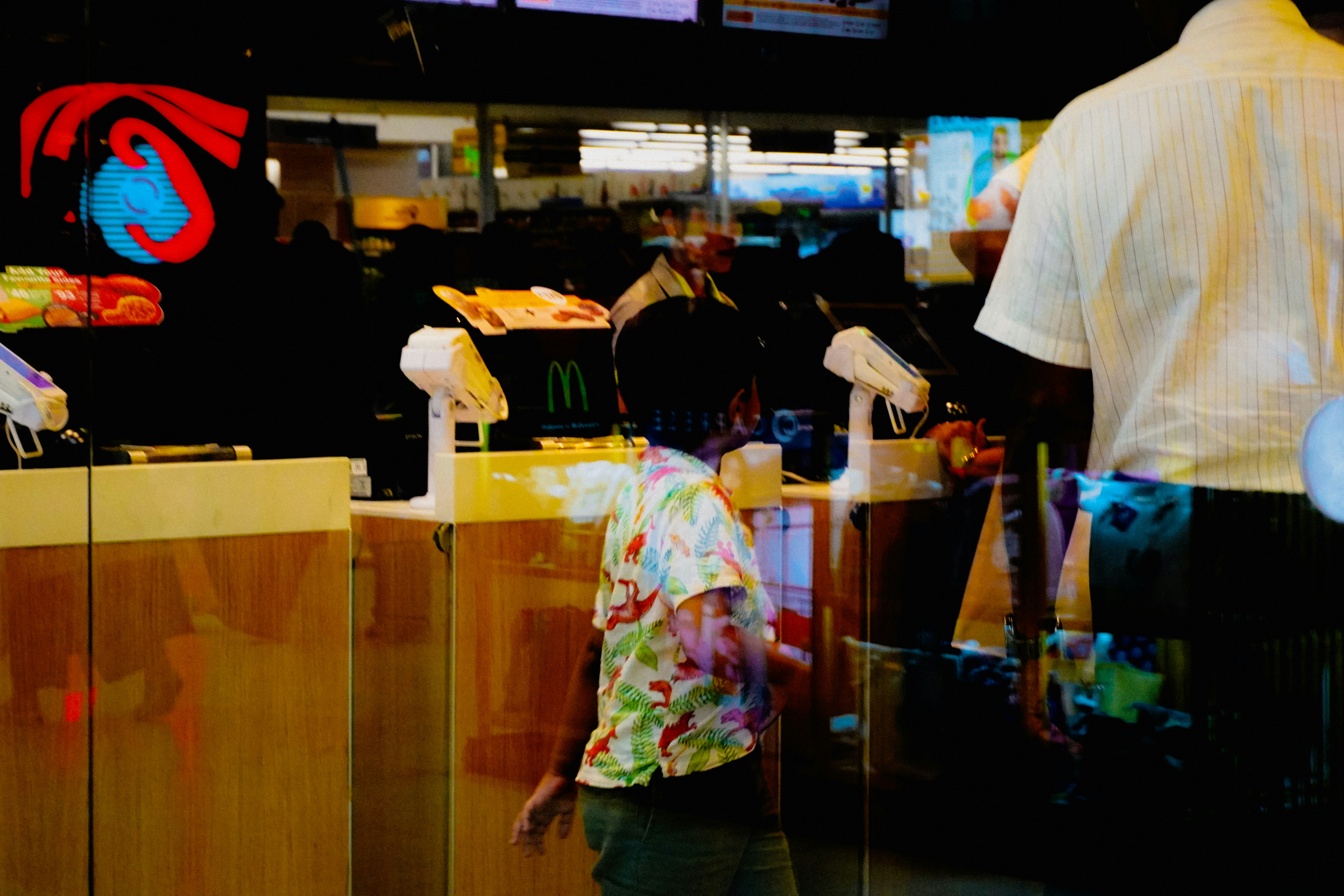 Child in colorful shirt at fast food counter