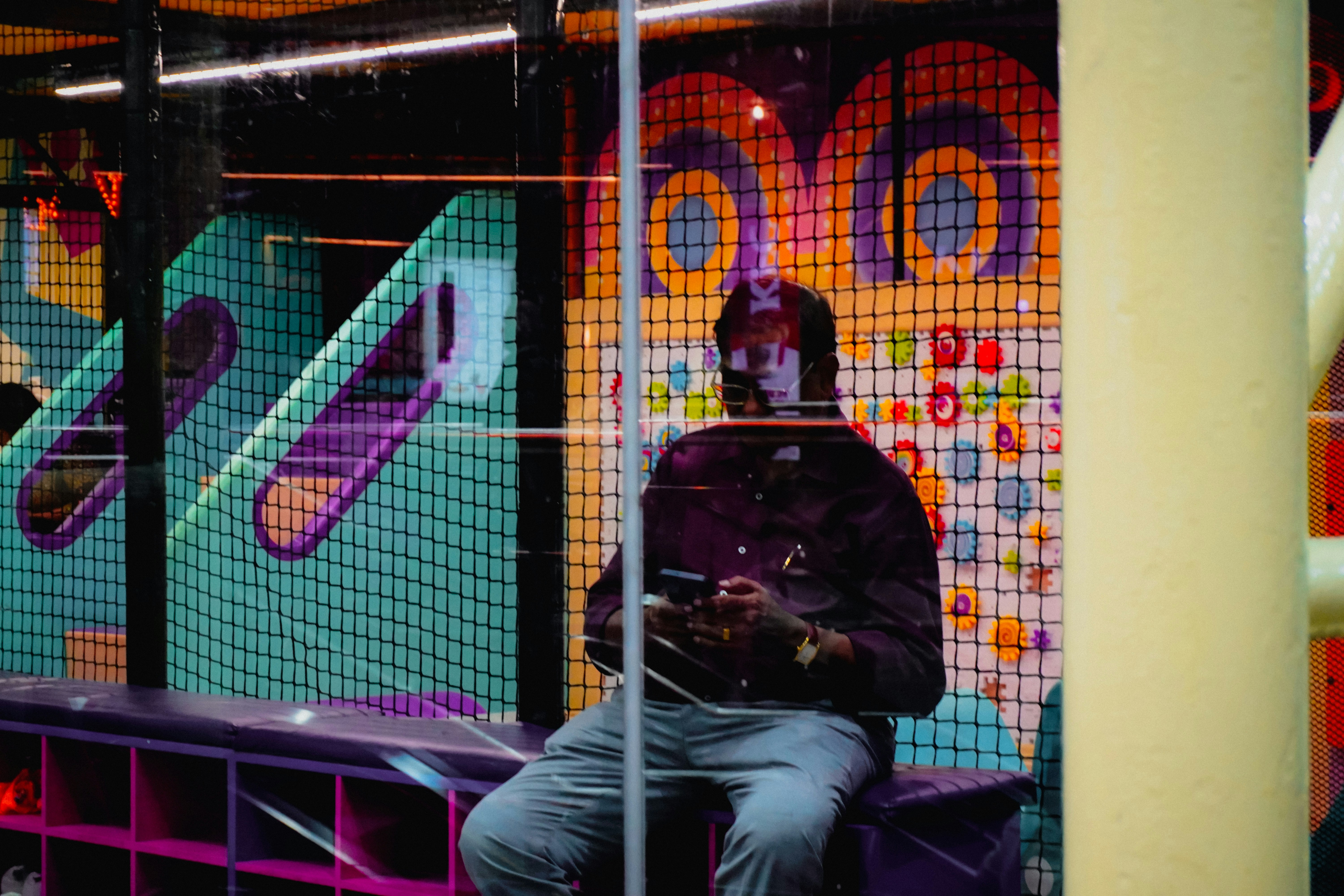 Man sits on bench looking at phone in phone