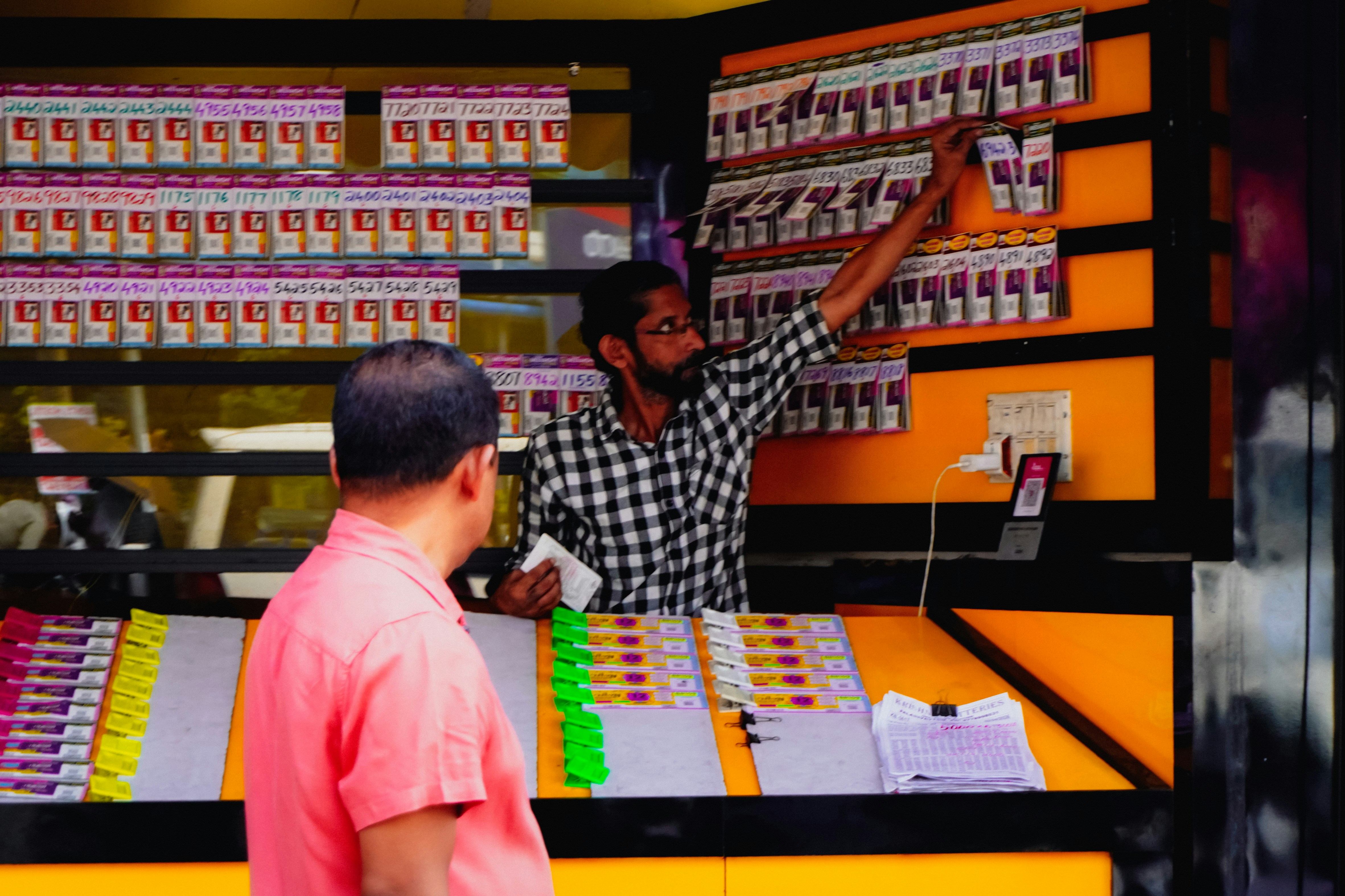 Man behind counter shows products to customer