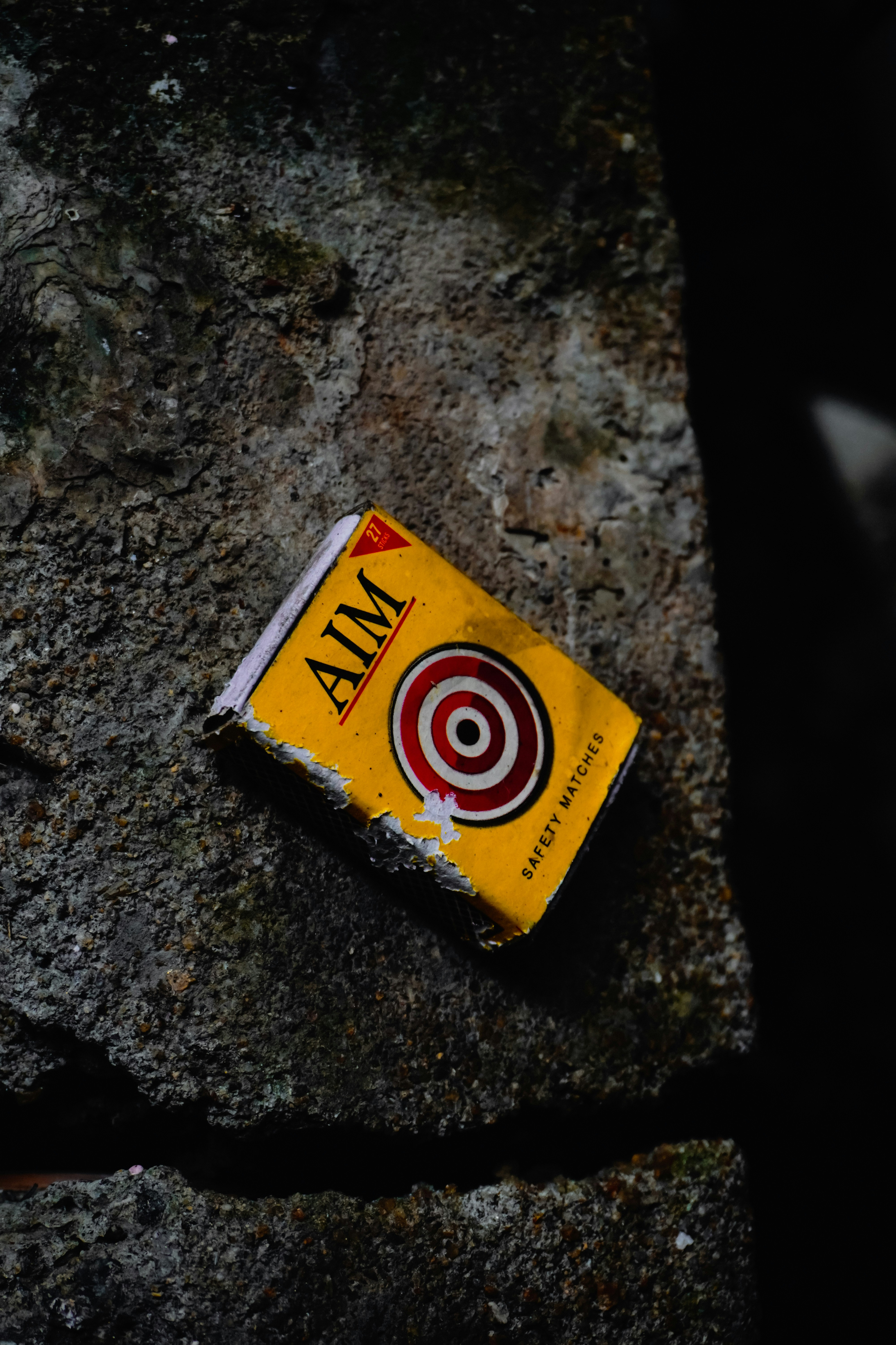 A yellow matchbox with the word aim on it