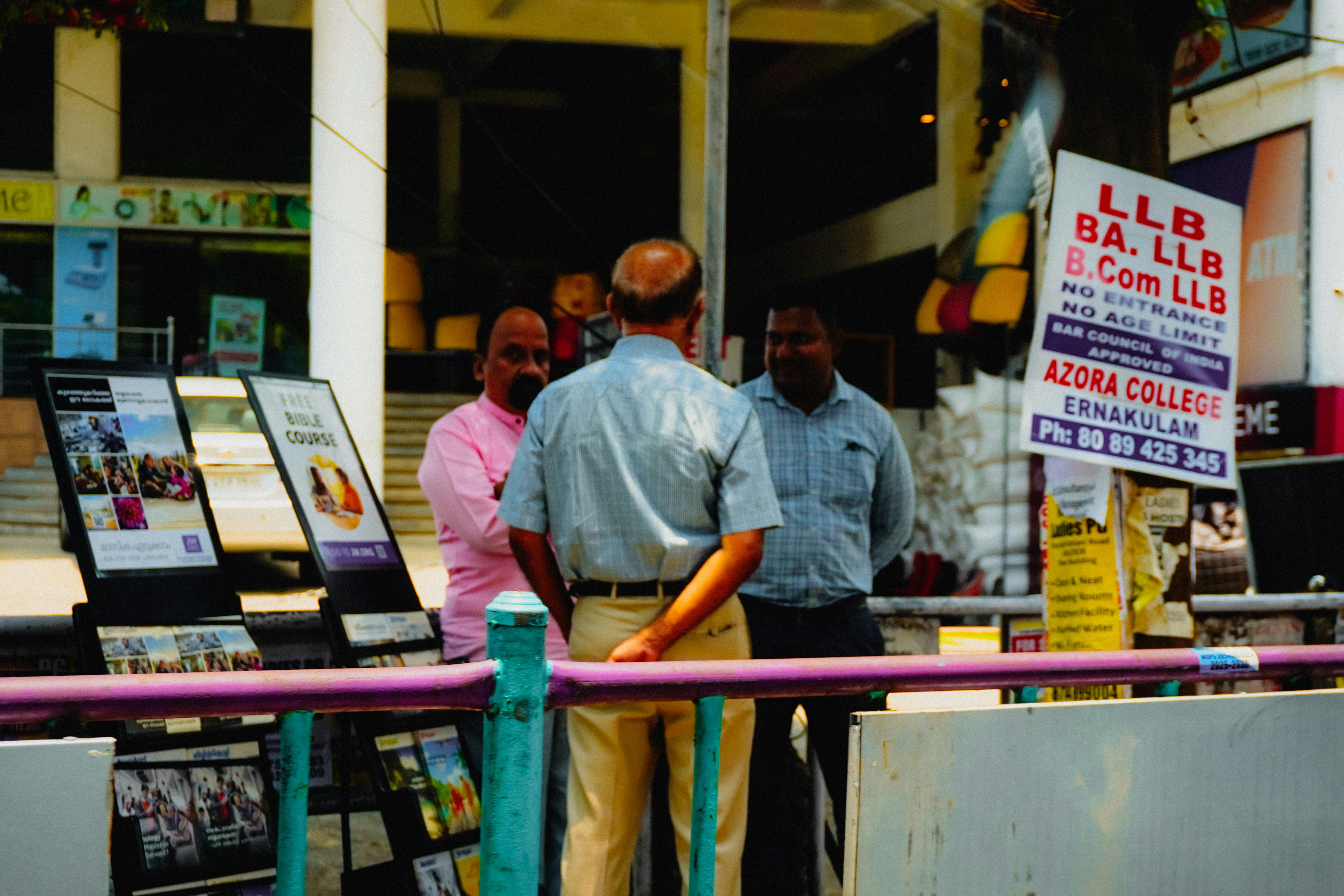 Men standing near a college advertisement board