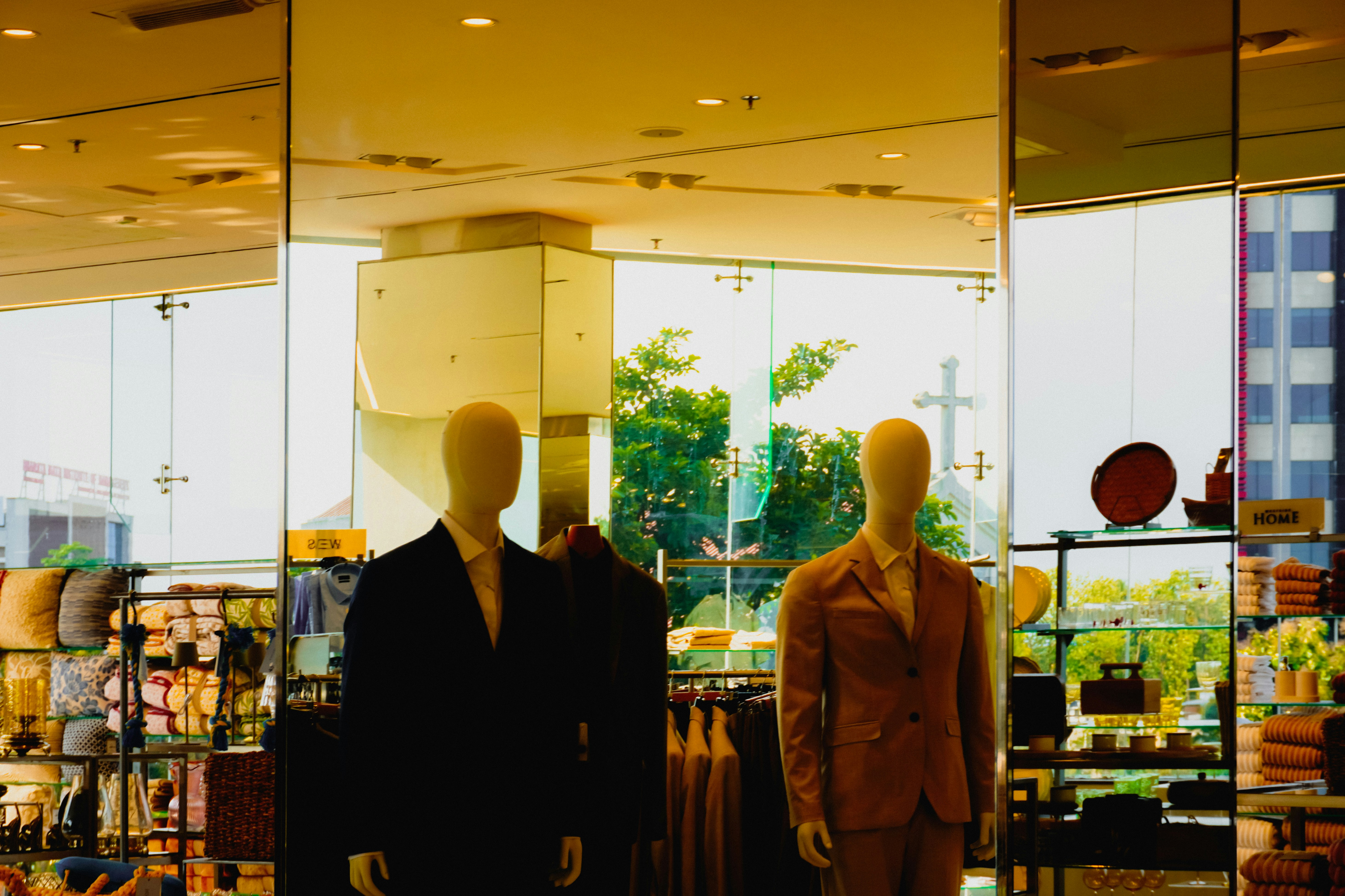 Dois manequins de terno estão em uma vitrine de loja.