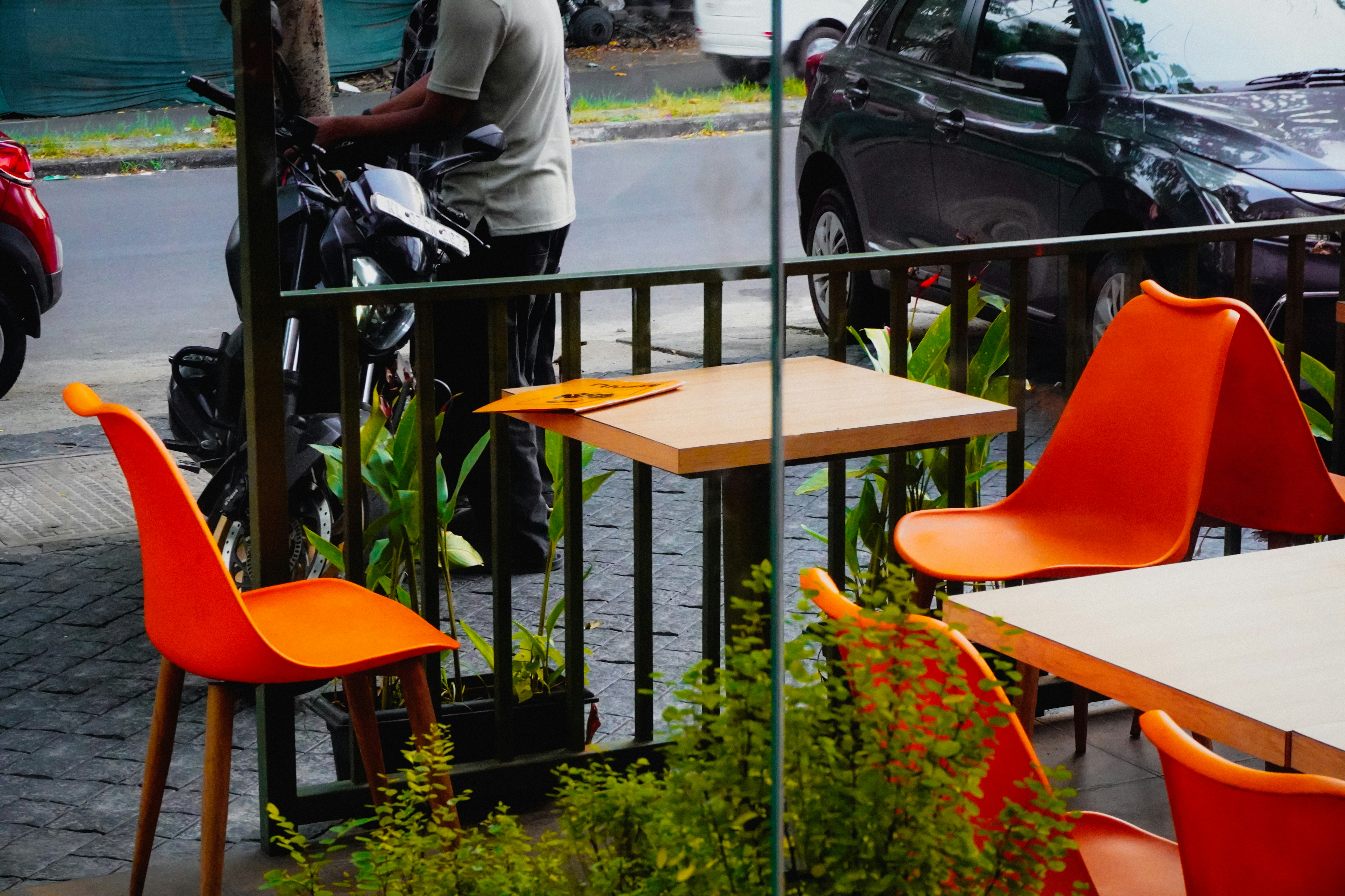 Outdoor cafe tables with bright orange chairs