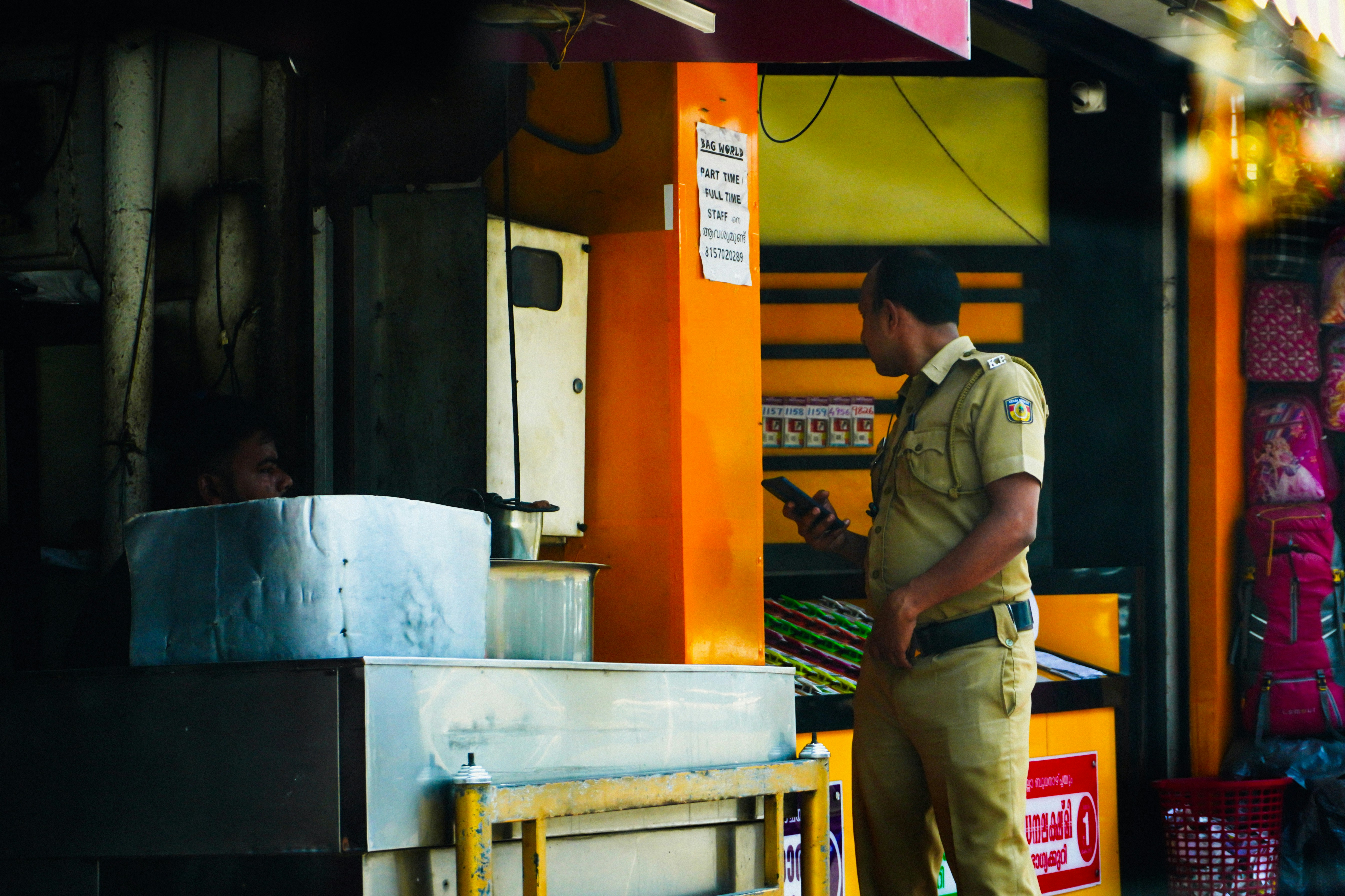 Un hombre uniformado está fuera de una tienda.
