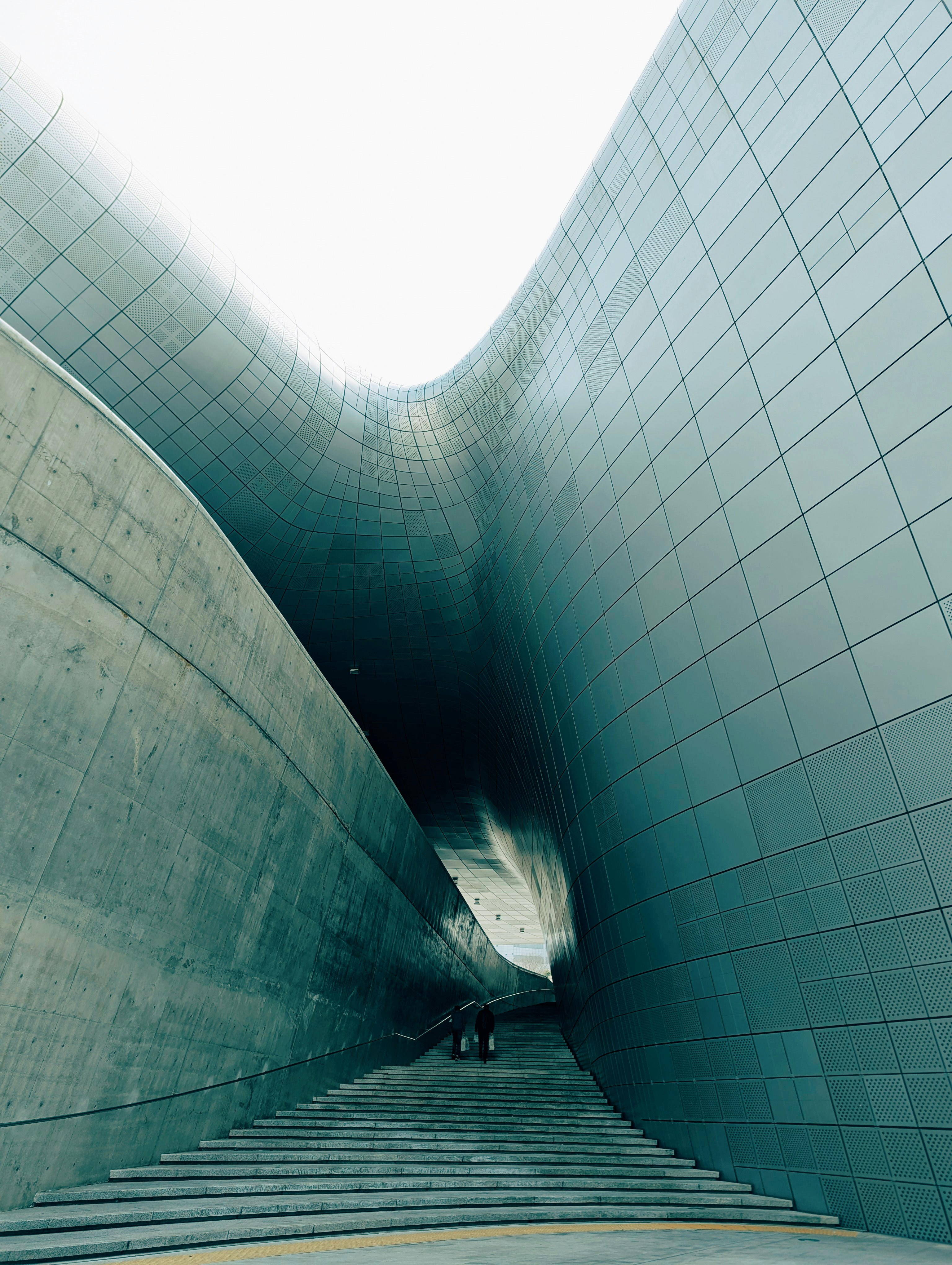 Modern architectural stairs leading into a curved tunnel.
