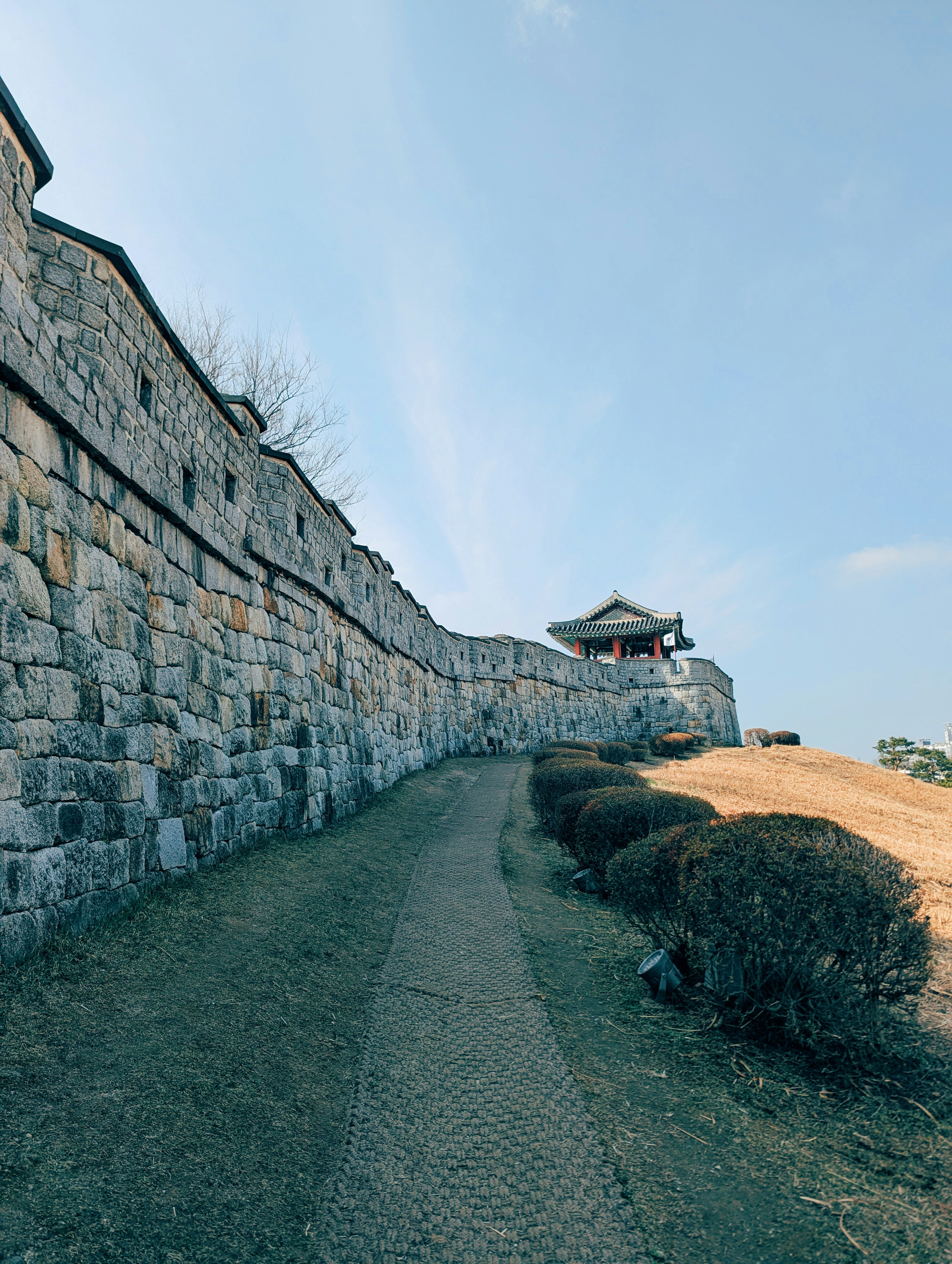 Stone fortress wall with a path and guard tower