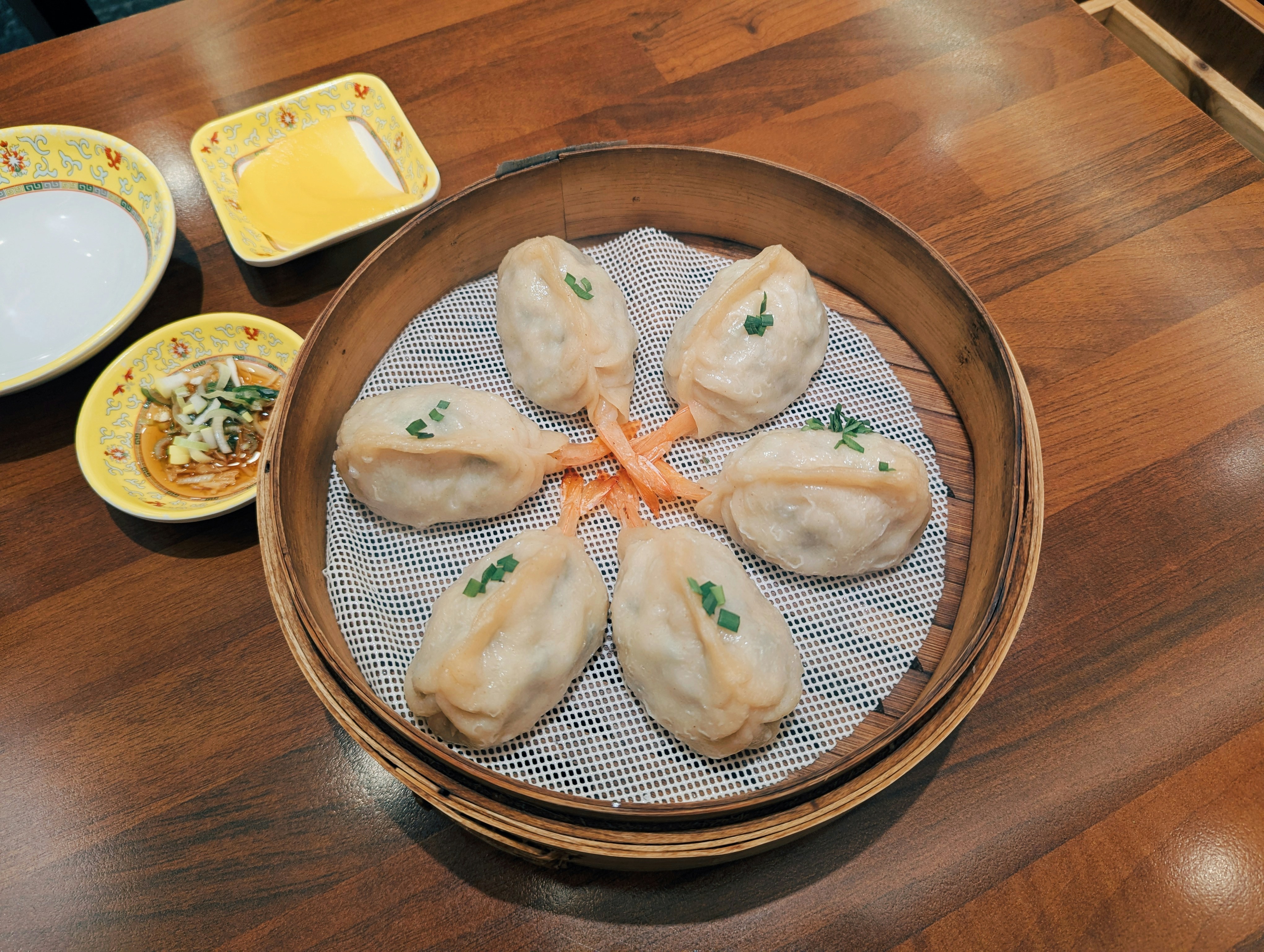 Fried dumplings arranged in a circle with dipping sauces.