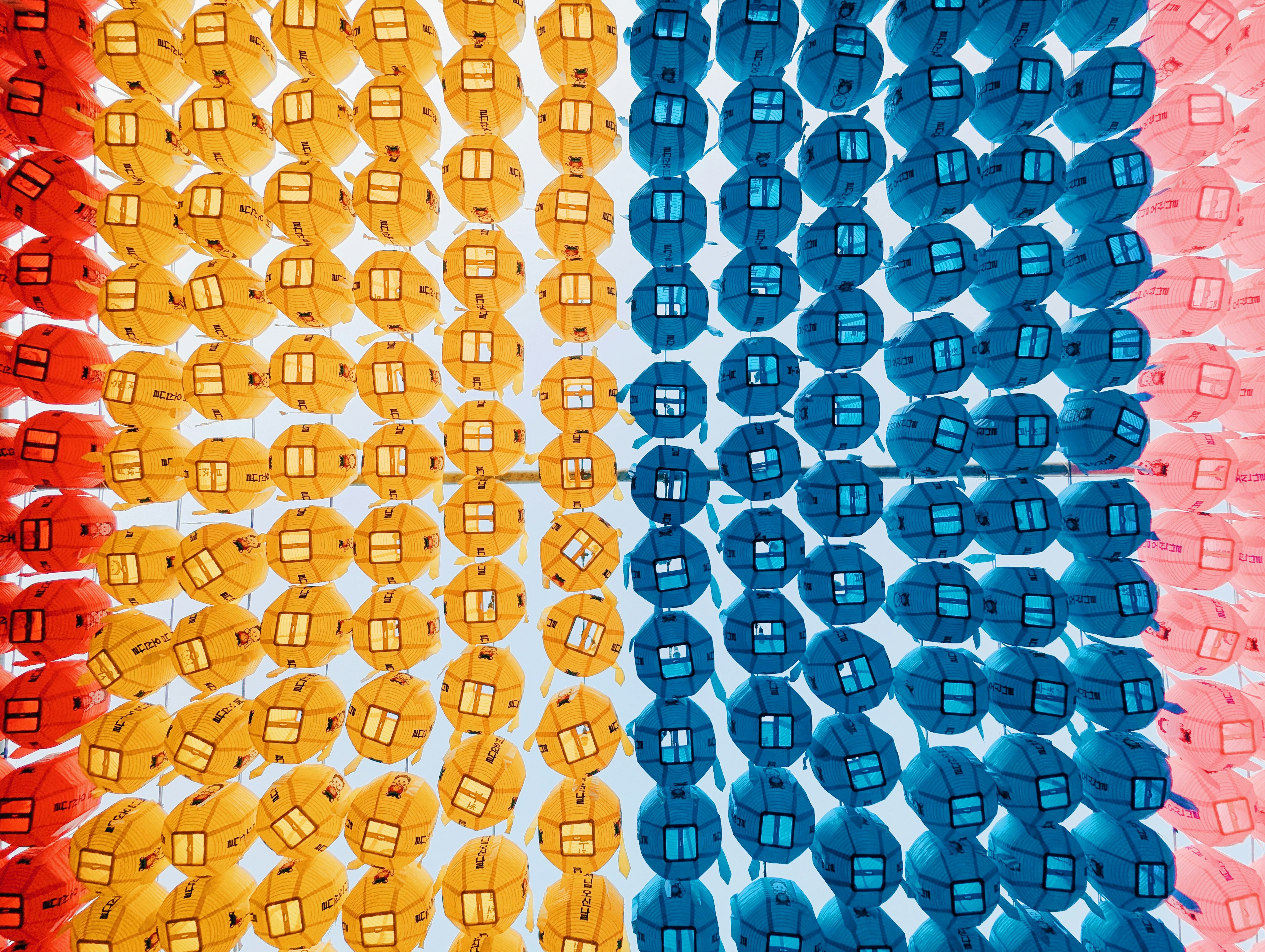 Rows of colorful lanterns in red, yellow, blue, and pink.