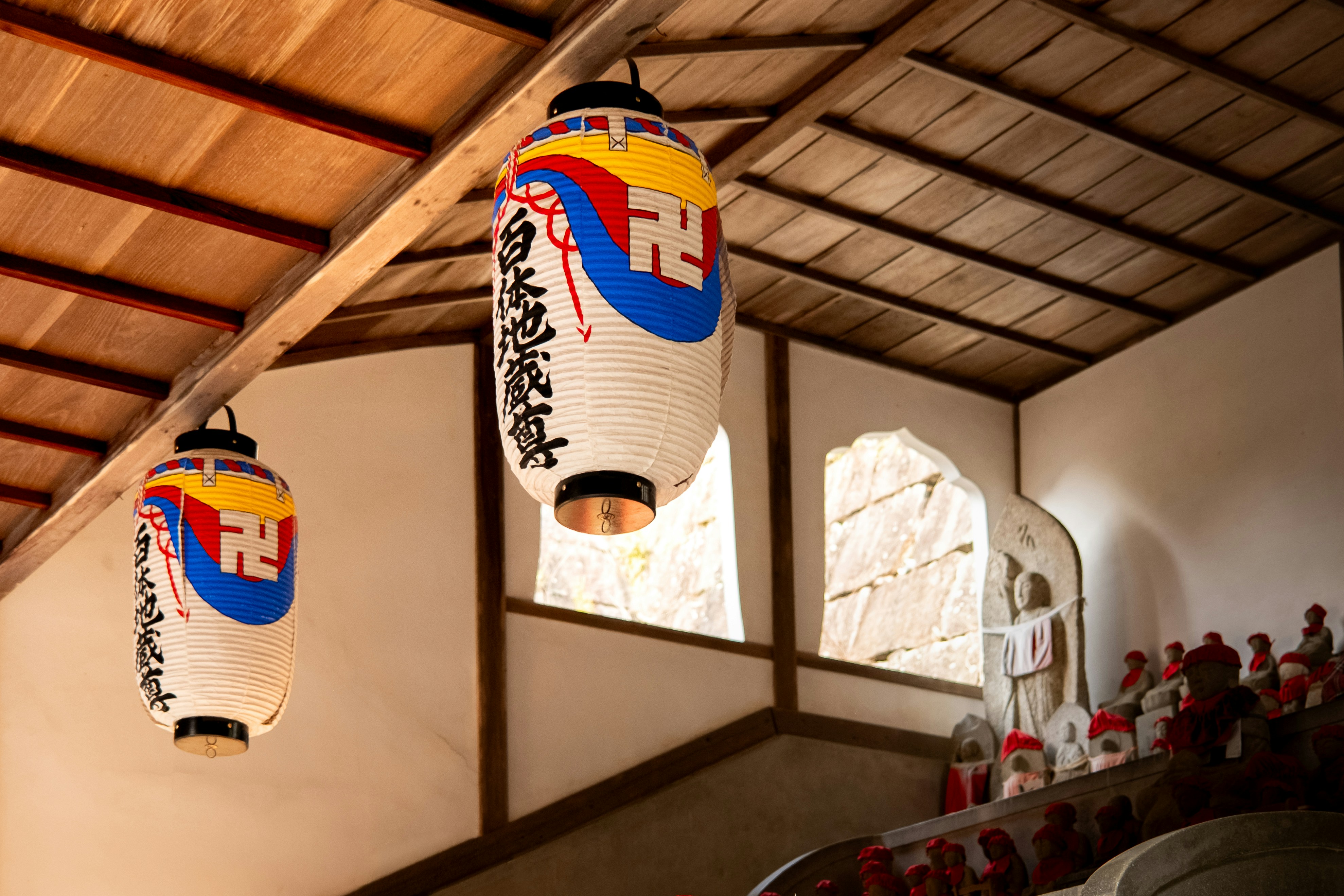 Deux lanternes japonaises pendent à un plafond en bois