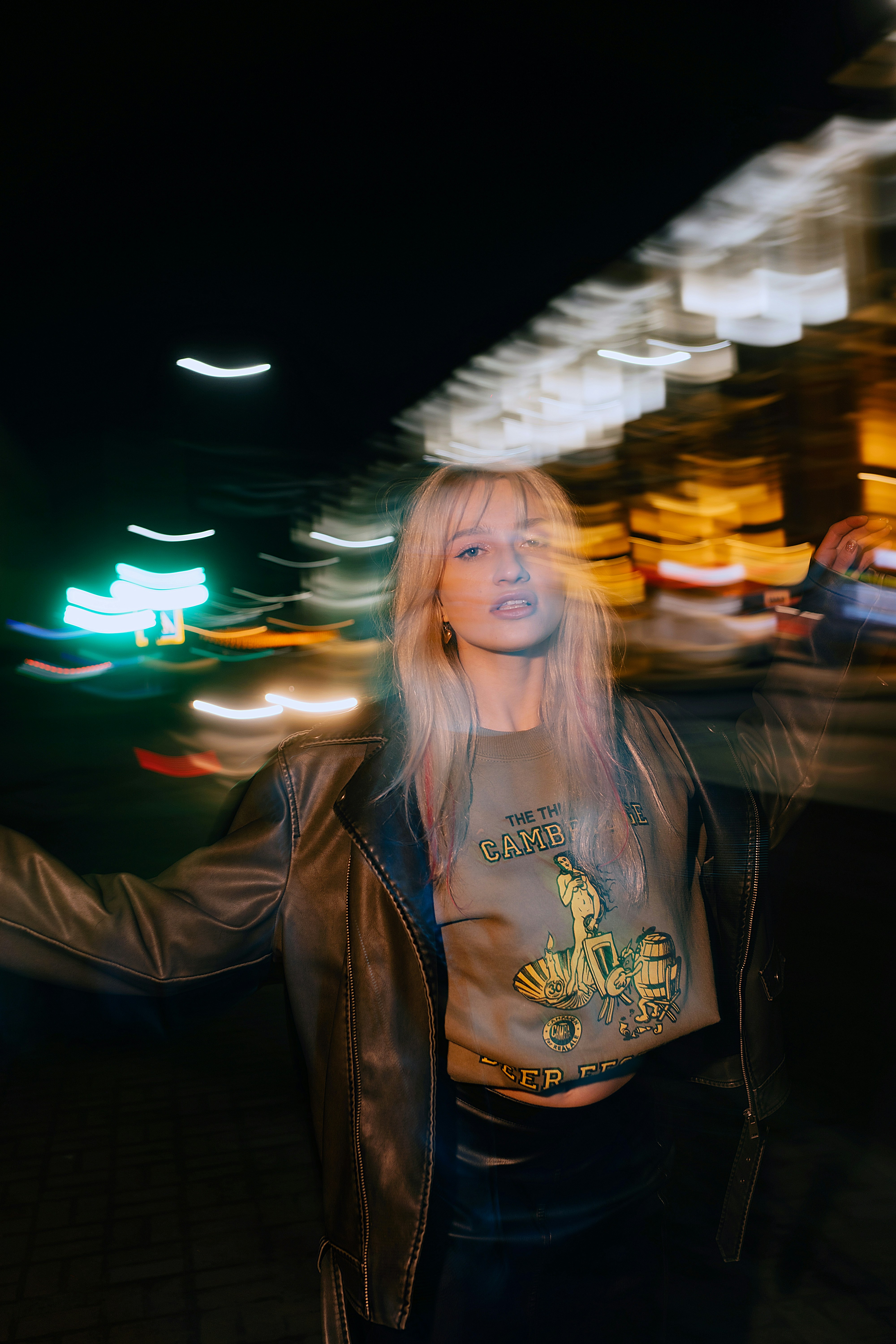 Woman with blonde hair in a leather jacket at night