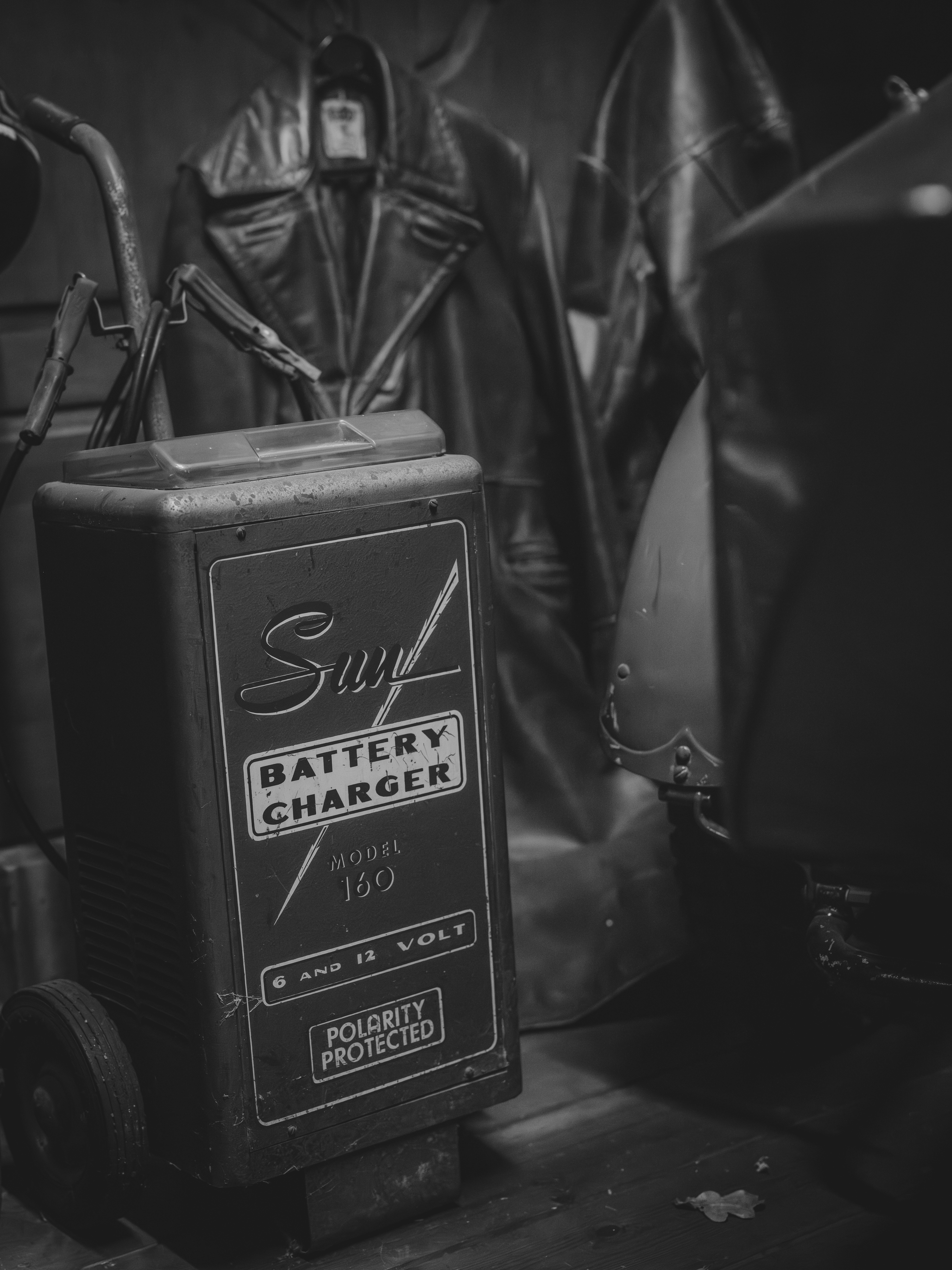 Chargeur de batterie vintage avec manteaux en cuir en arrière-plan