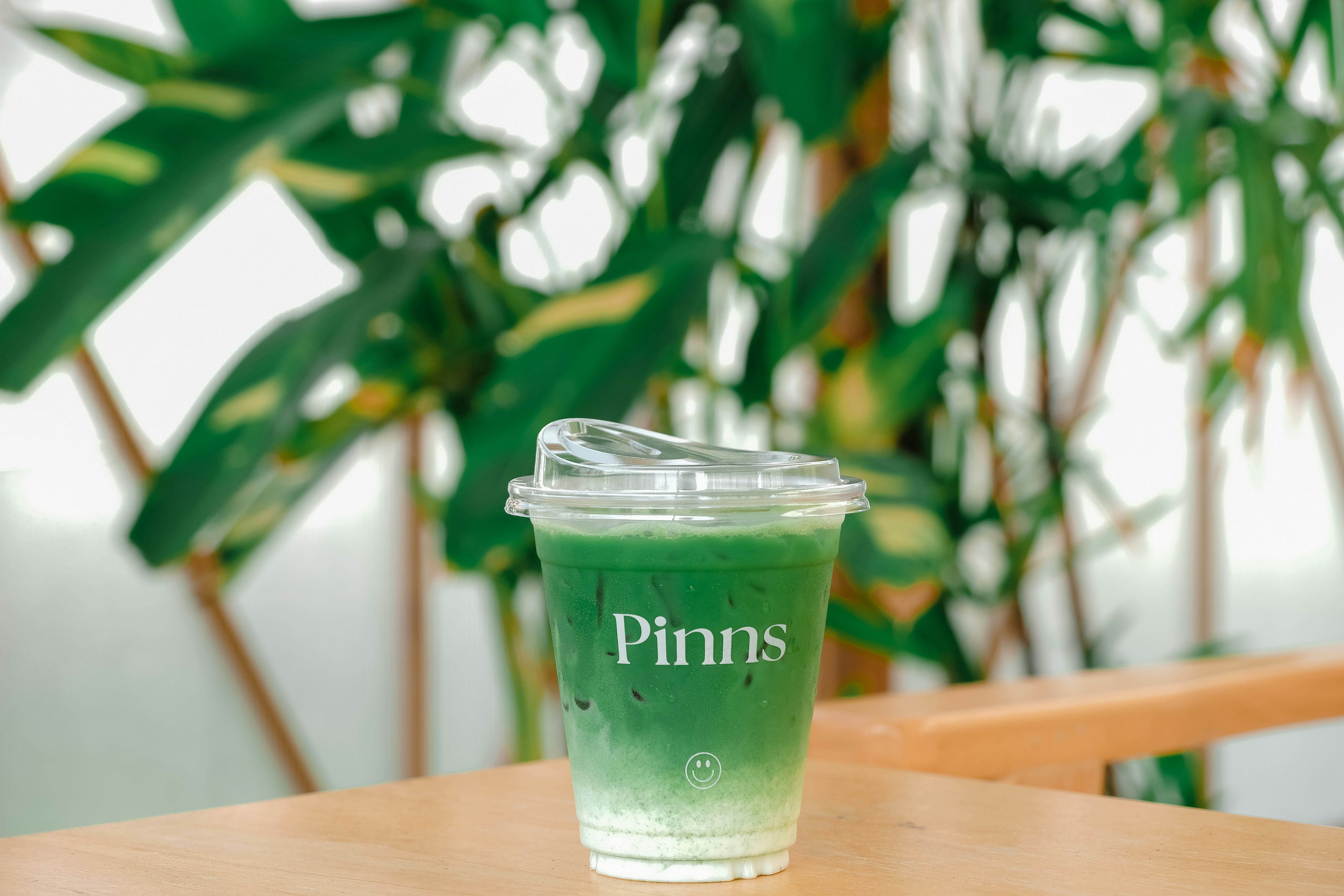 Green matcha latte with milk on a wooden table