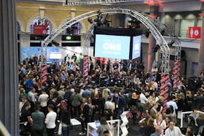 Crowd gathered at an indoor event with a large screen