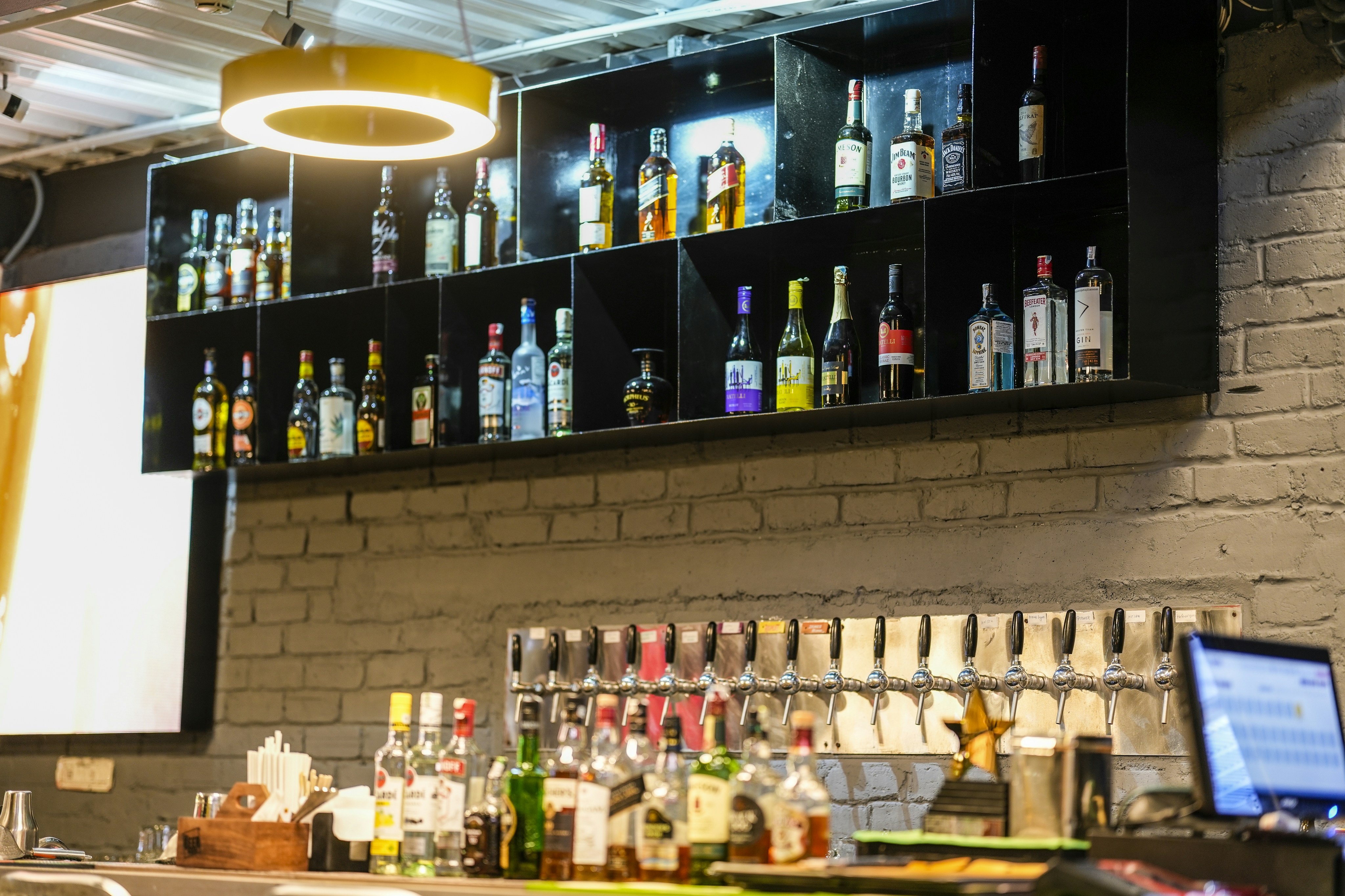 Bottles of alcohol displayed on shelves behind a bar counter.