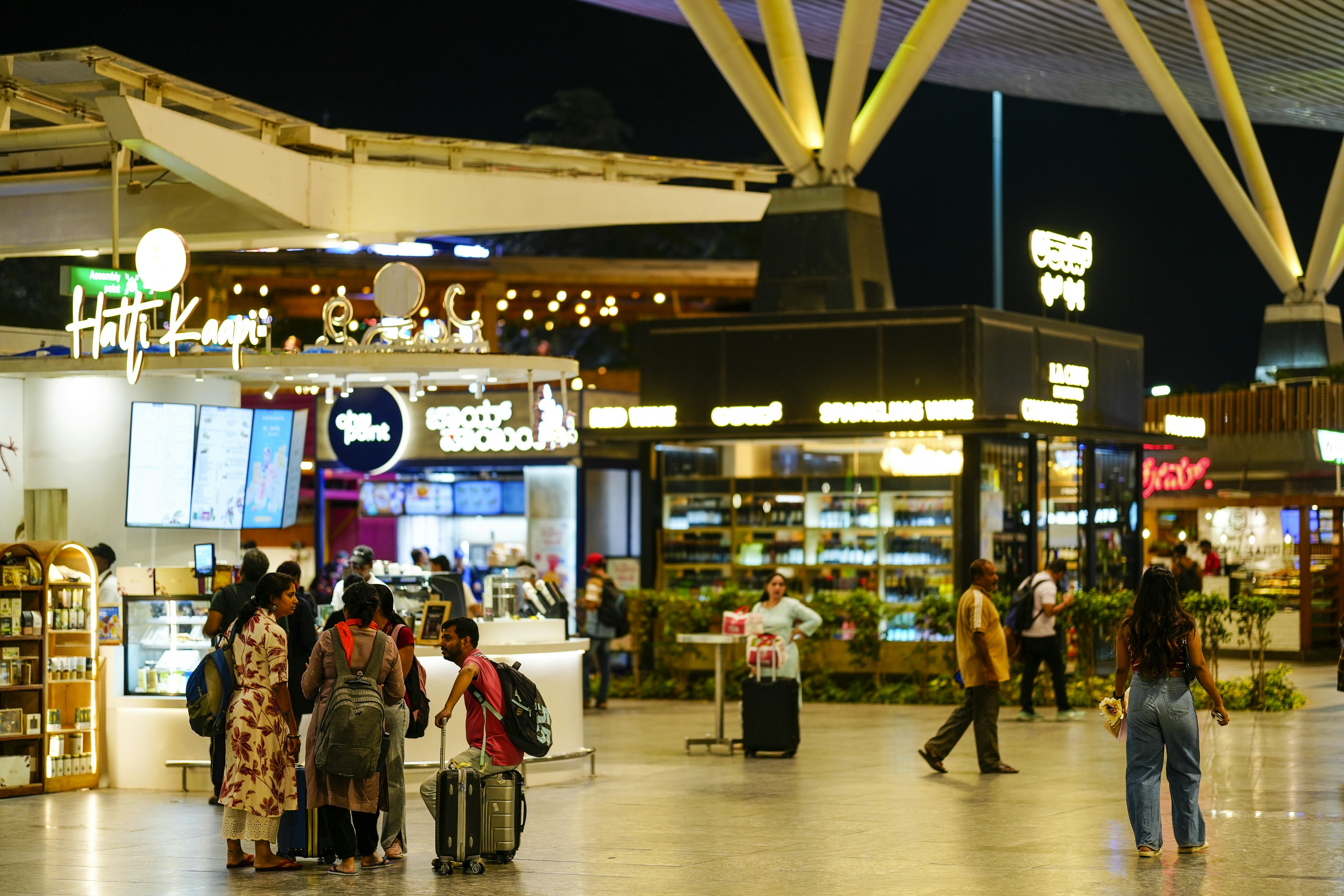 People walking through a modern airport terminal at night