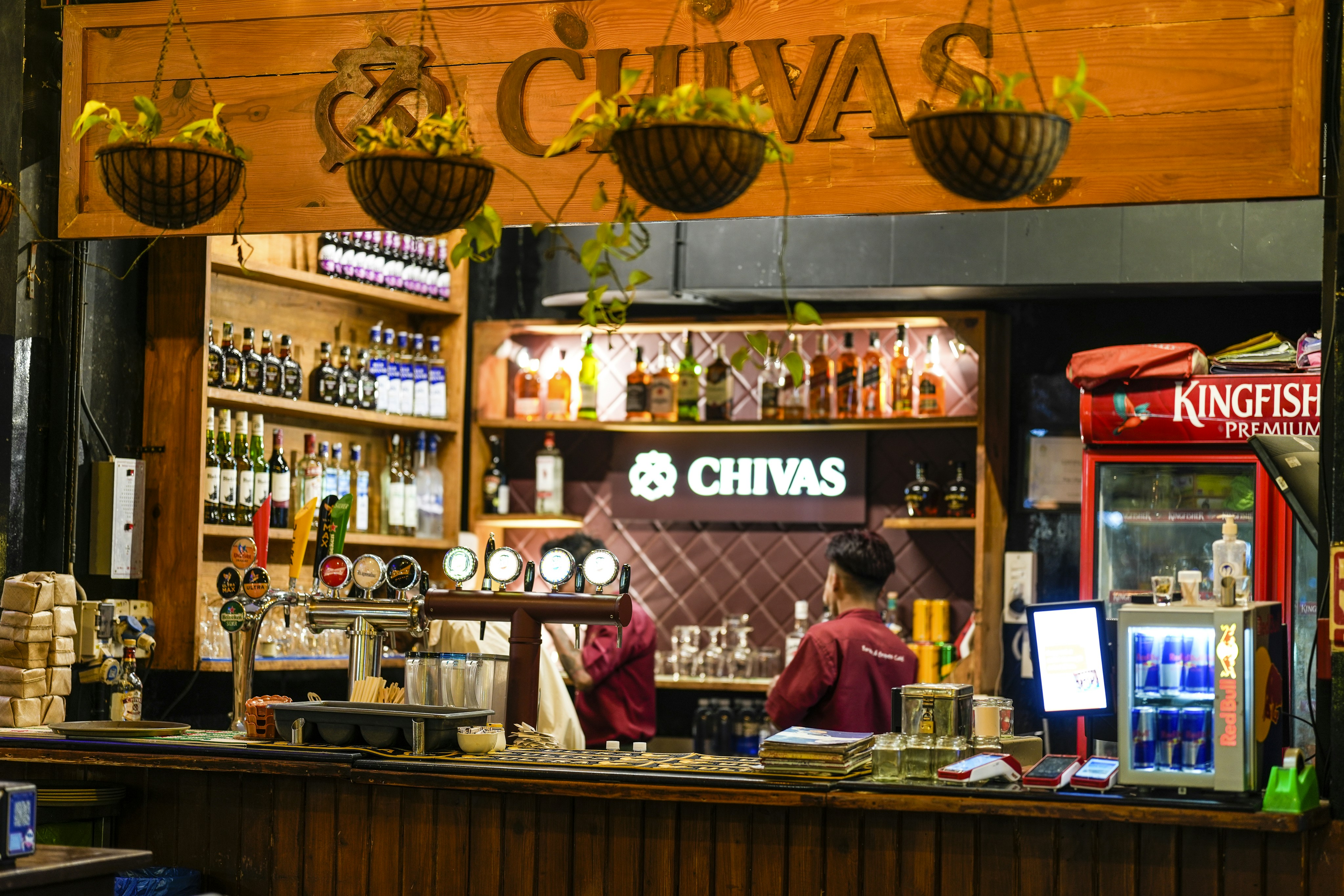 A bar with bottles of alcohol and a bartender