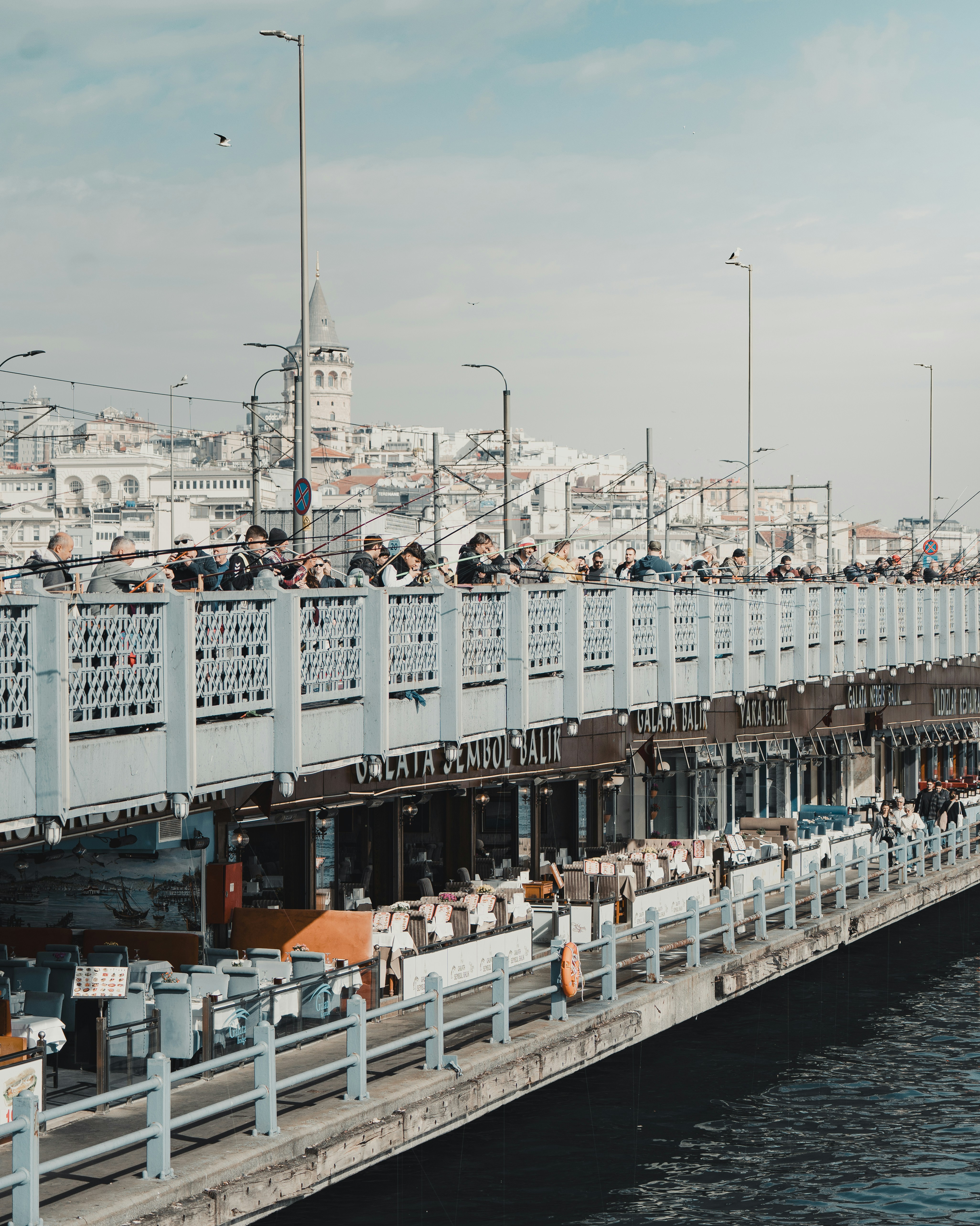 Gente caminando por un puente con edificios de la ciudad de fondo