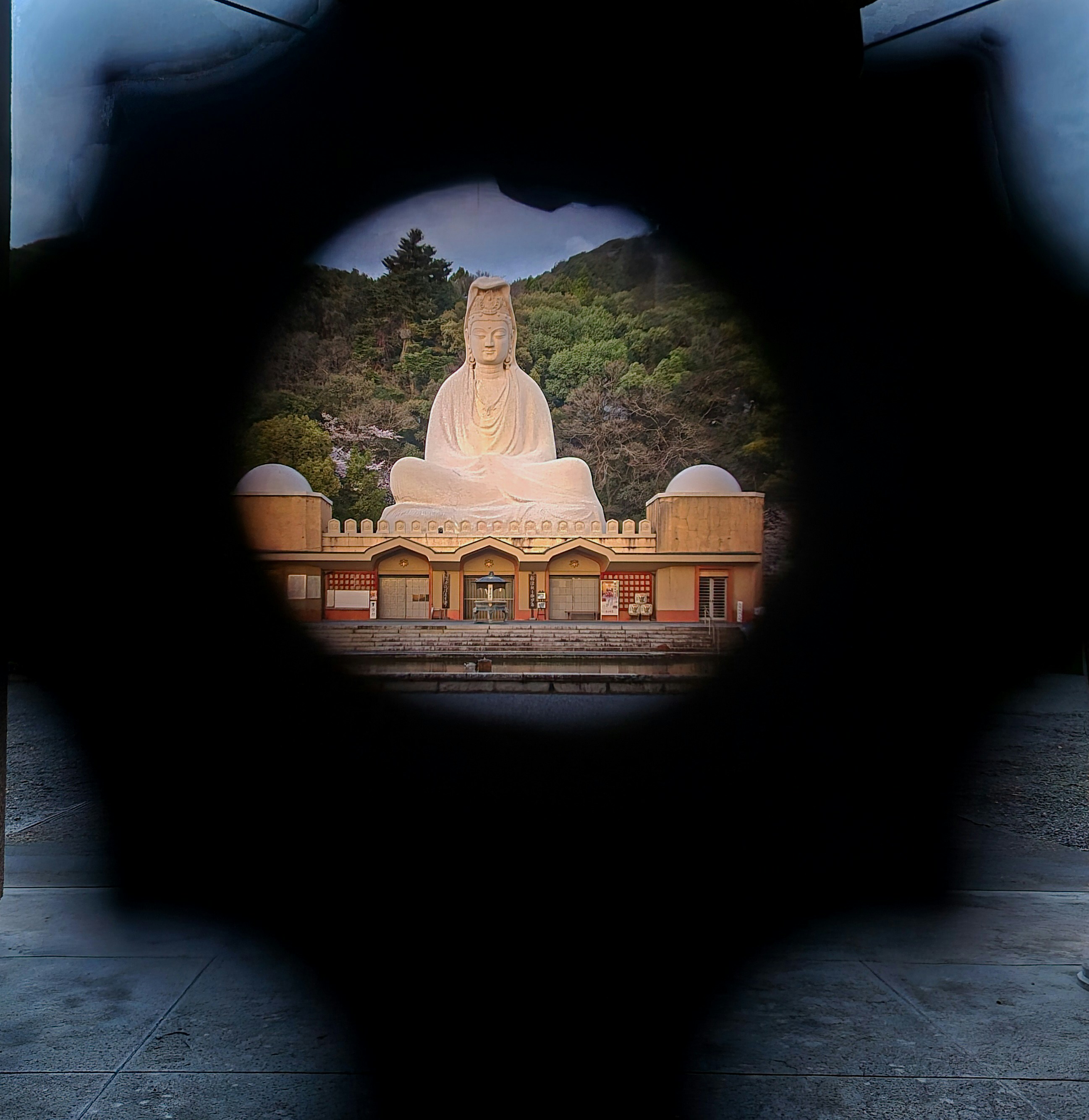 Large buddha statue framed by a star-shaped opening.