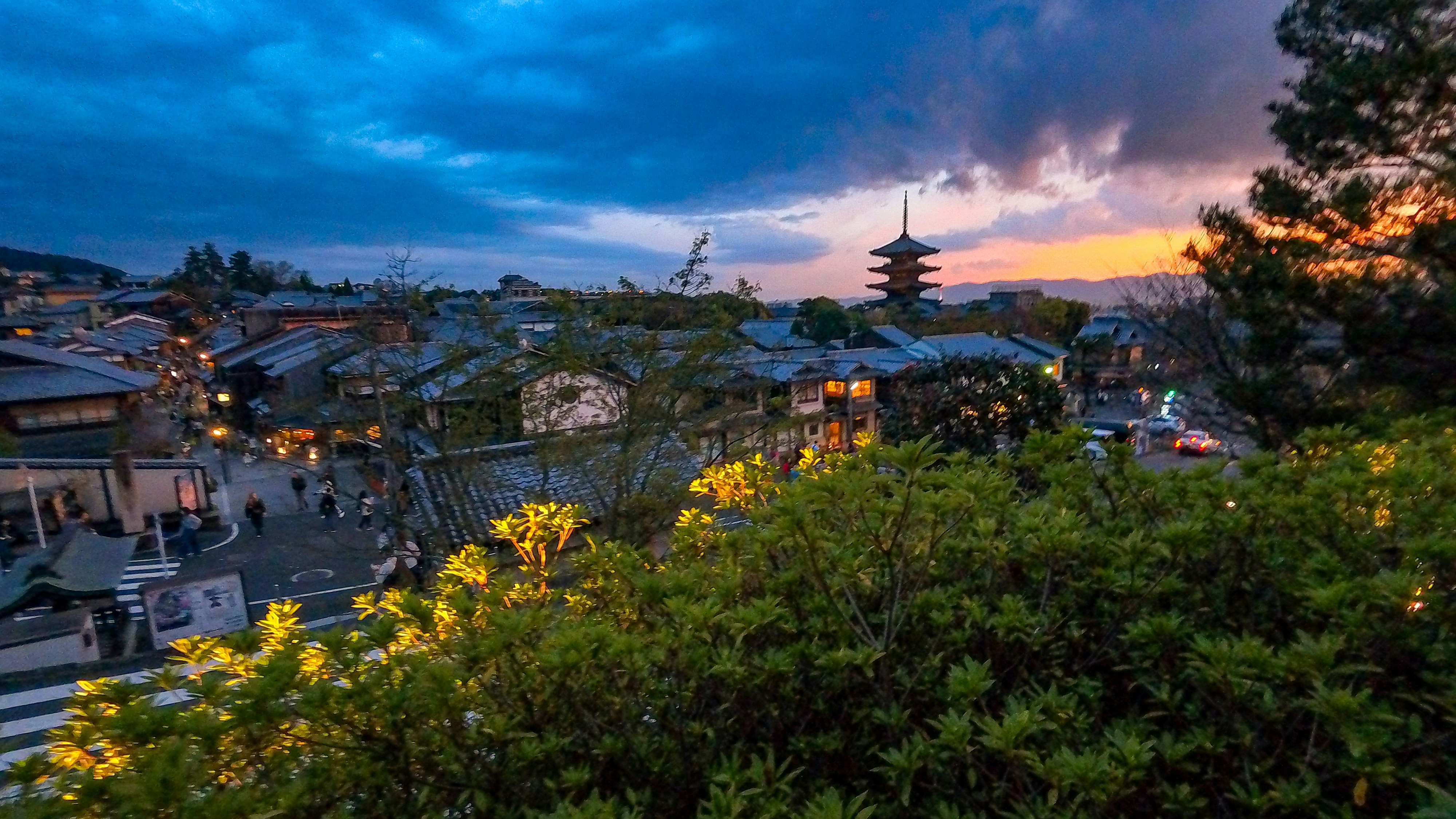 Traditional japanese pagoda overlooking a town at dusk
