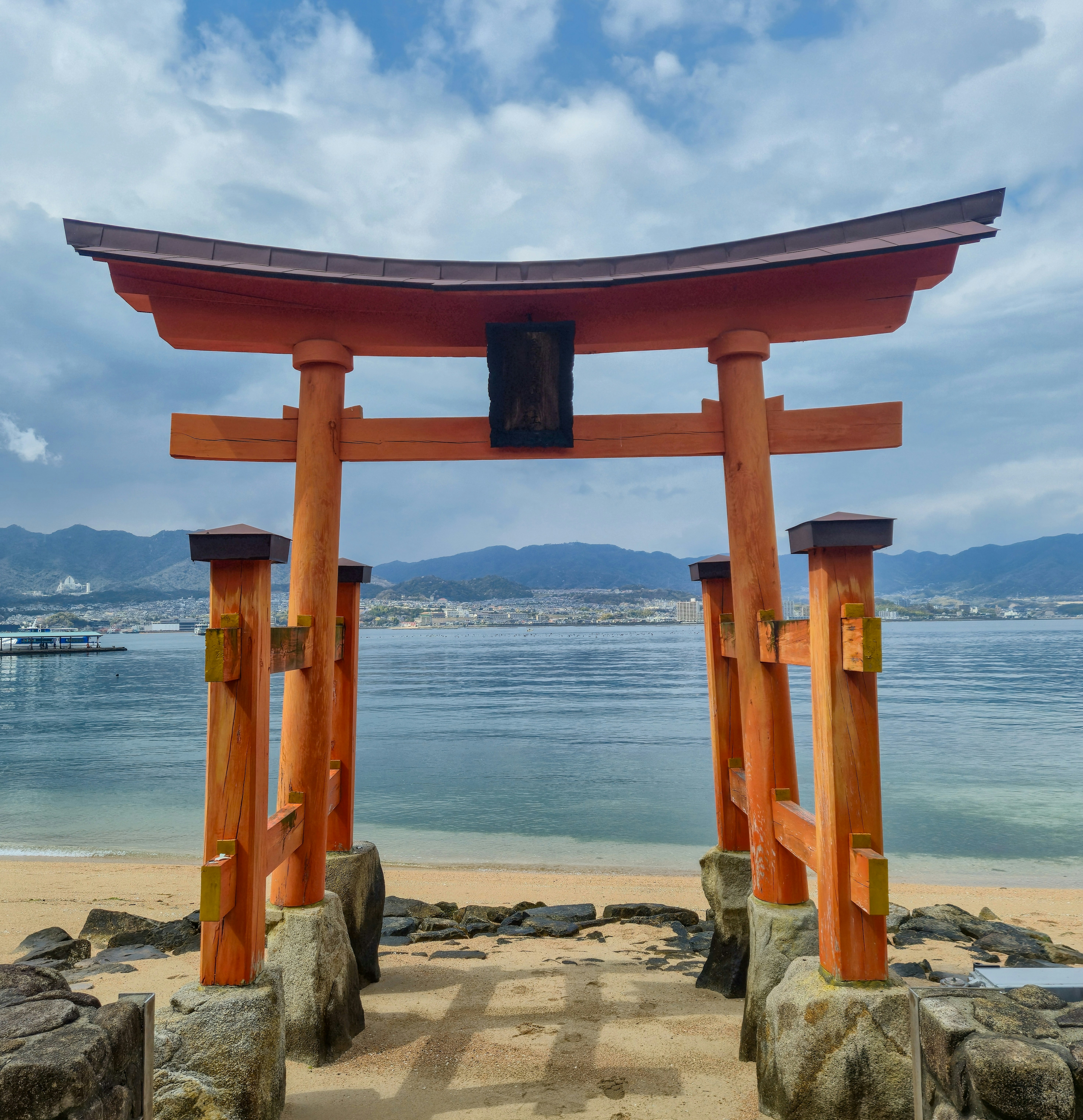 Orange torii gate on a beach by the water
