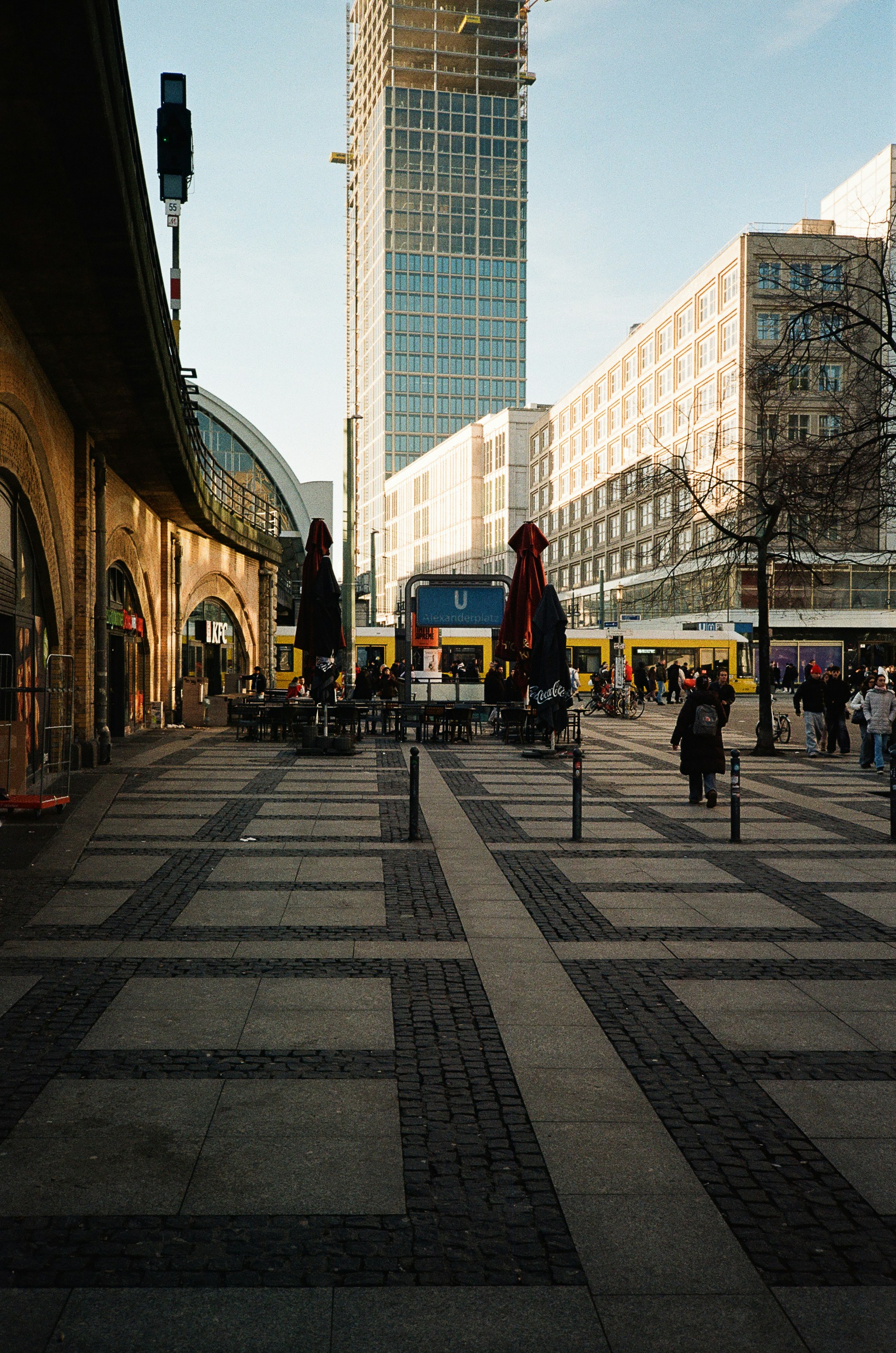 Strada cittadina con edifici moderni e persone che camminano.